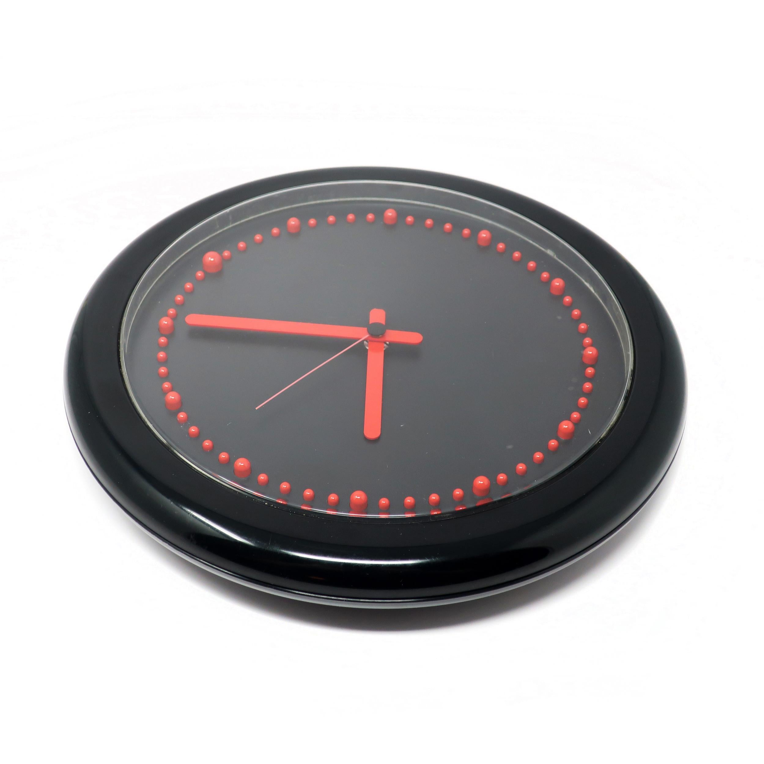 Designed by Raul Barbieri and Giorgio Marianelli for Rexite in 1981, this Zero 980 wall clock has a striking black and red combination. Black plastic case, REd hands, and raised red plastic bumps for the clock's numbers and a black face. Perfect