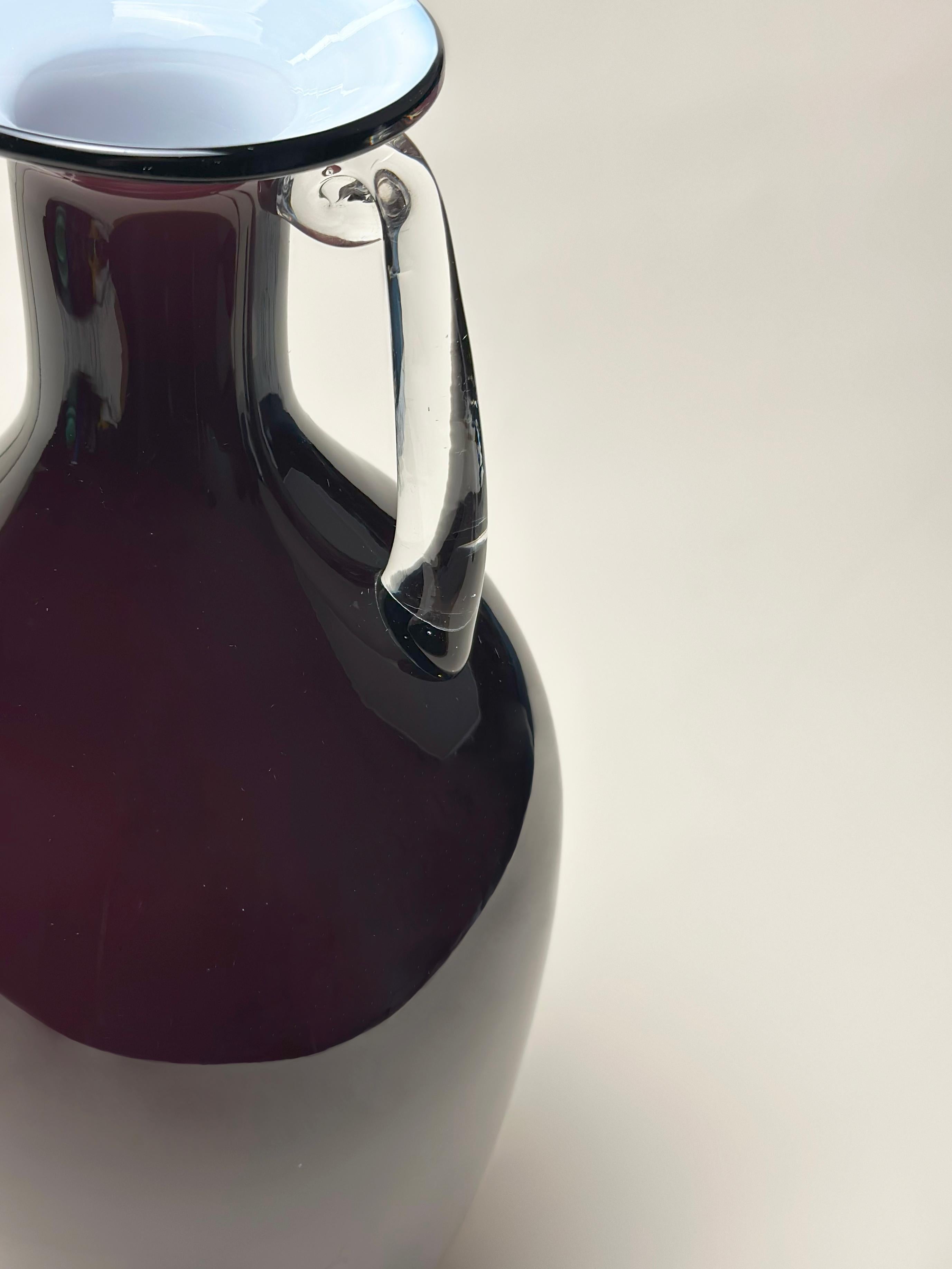 Un audace e scultoreo vaso in vetro incamiciato disegnato da Jerzy Słuczan-Orkusz e prodotto dalla vetreria Tarnowiec, in Polonia, durante gli anni '80. Questo pezzo riflette una reinterpretazione decisamente postmoderna dell'anfora classica,