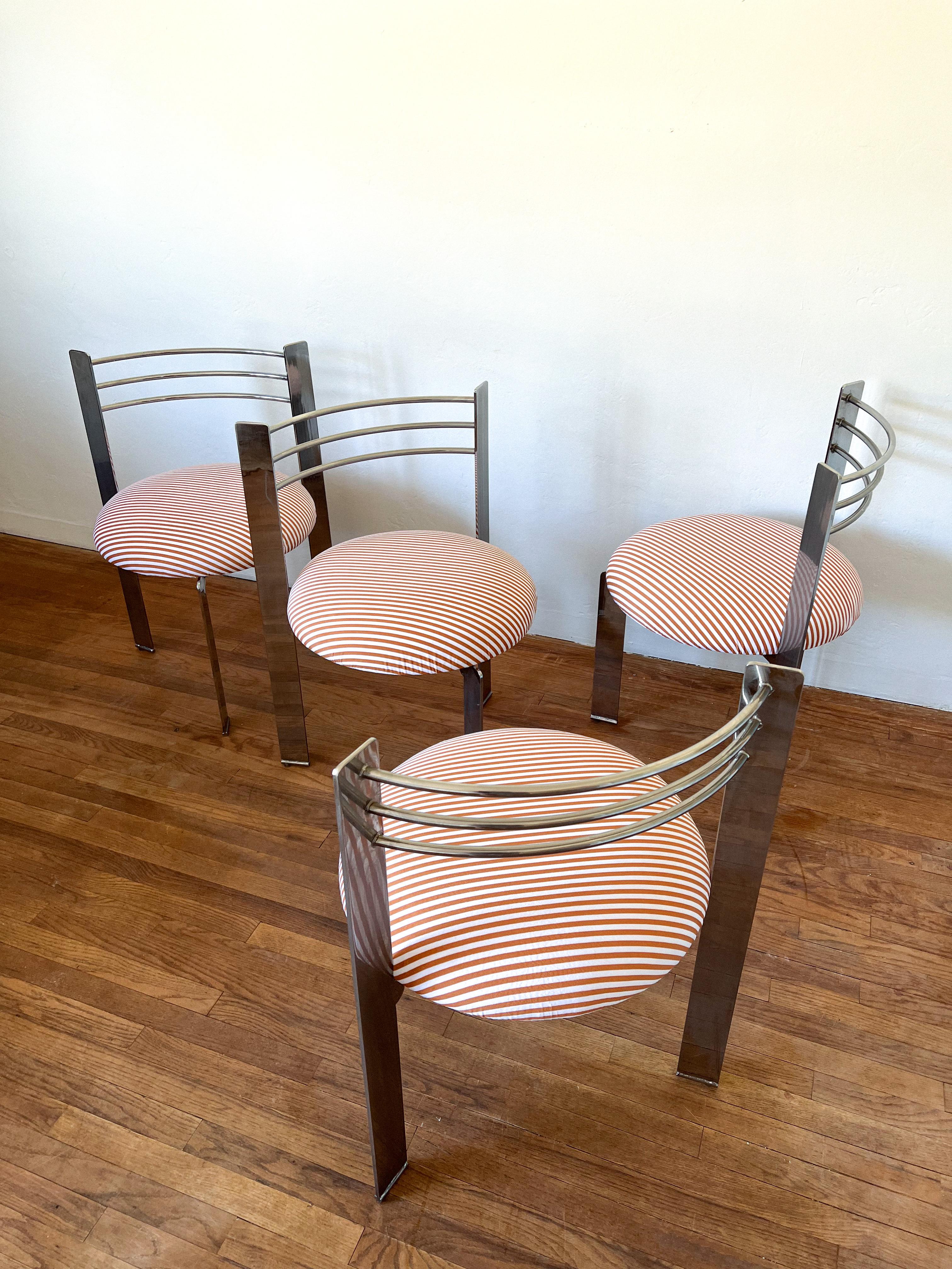 Set of four Memphis style dining chairs. Heavy and sturdy tripod chrome frames with newly reupholstered seats featuring a high end ultra modern performance velvet fabric with cream and mustard stripes.