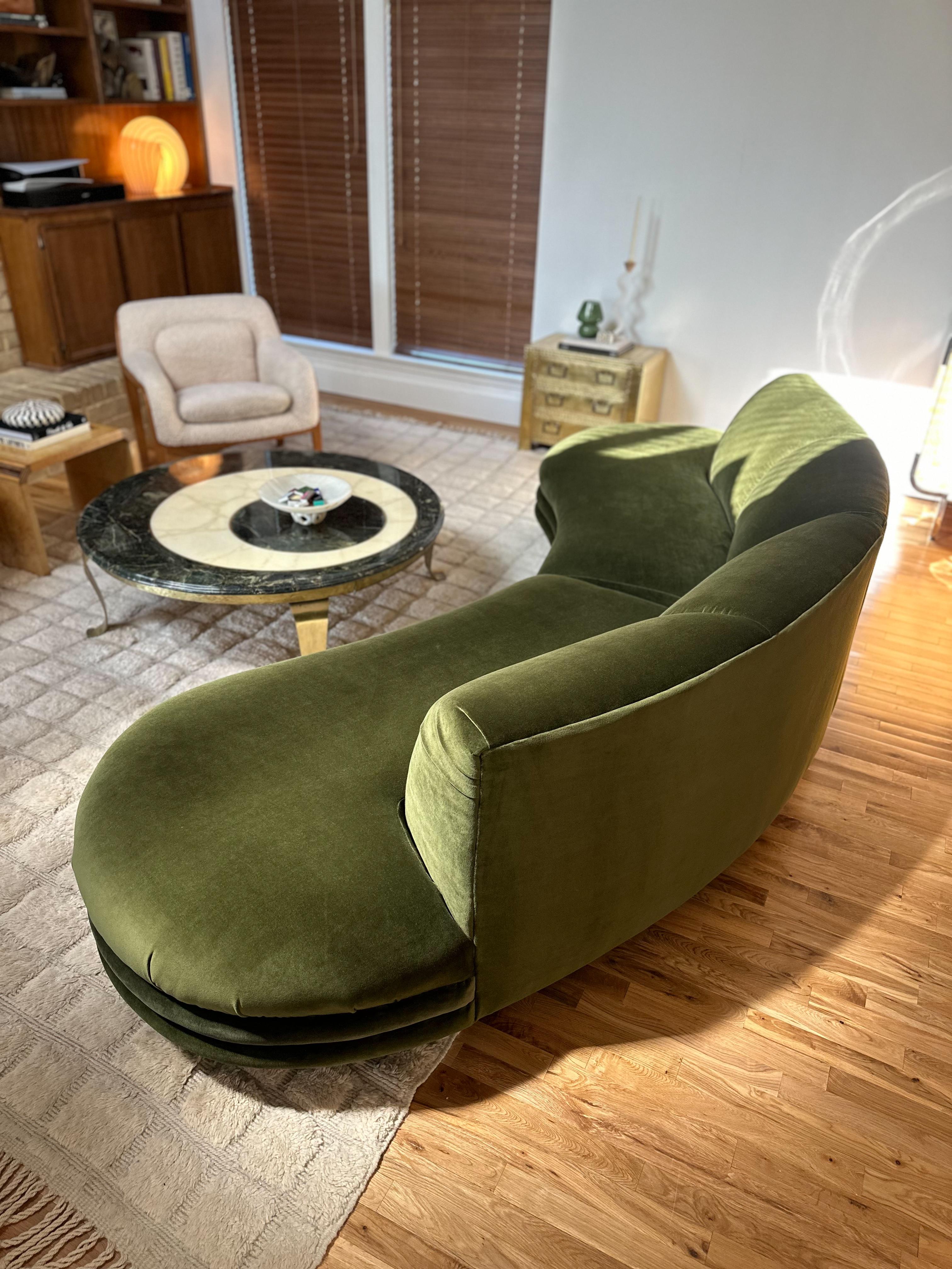 Gorgeous postmodern two piece curved sectional freshly reupholstered in olive velvet, c.1980s. While unmarked, the design is very reminiscent of those by Bernhardt Flair Division and Adrian Pearsall. With its upholstered plinth base, scalloped front