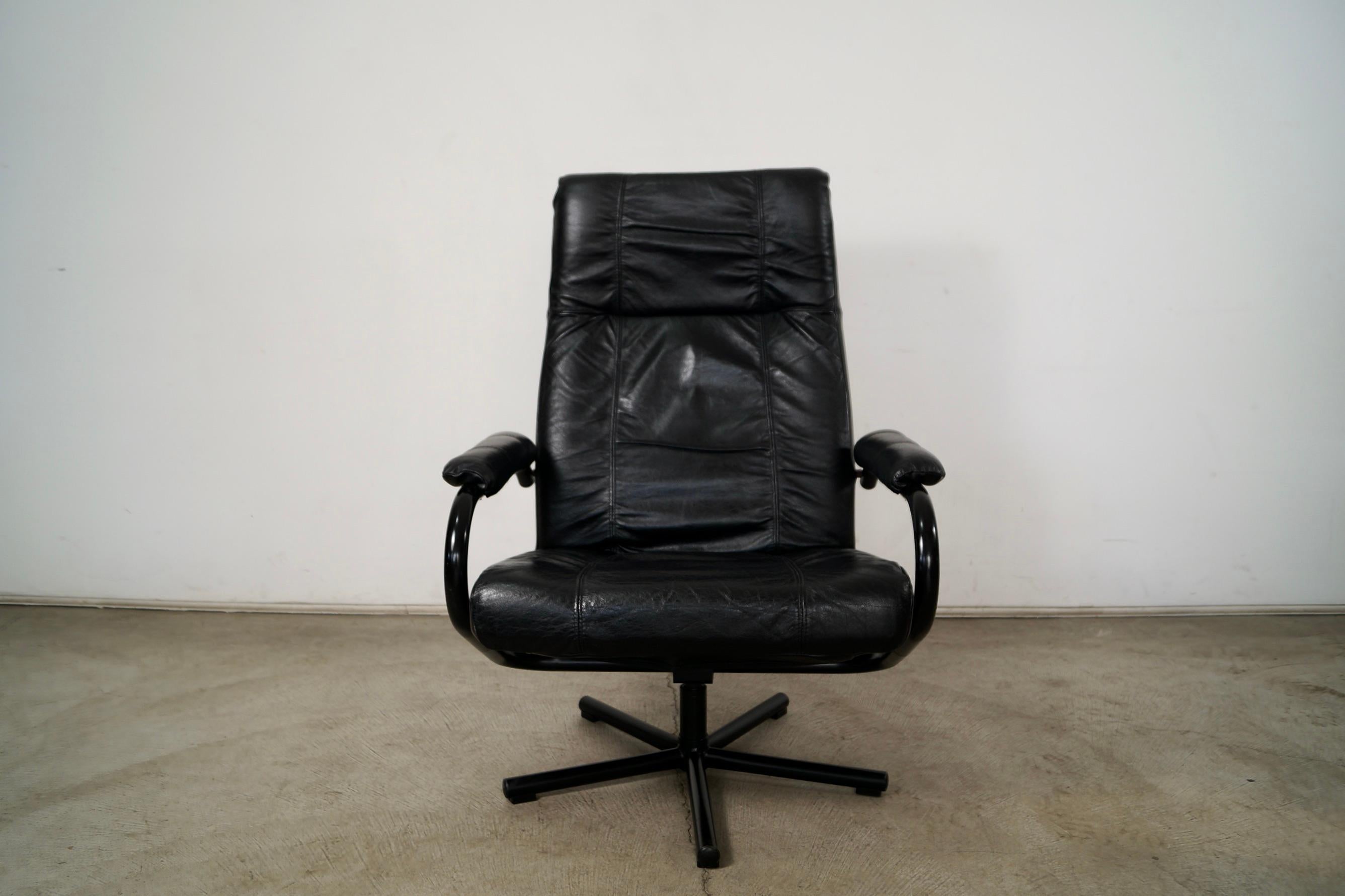 Vintage Post Modern lounge chair for sale. It's a special and rare one manufactured by Kebe and was made in Denmark. It's genuine black leather with a black metal frame. The metal frame is in excellent condition along with the black metal base. The