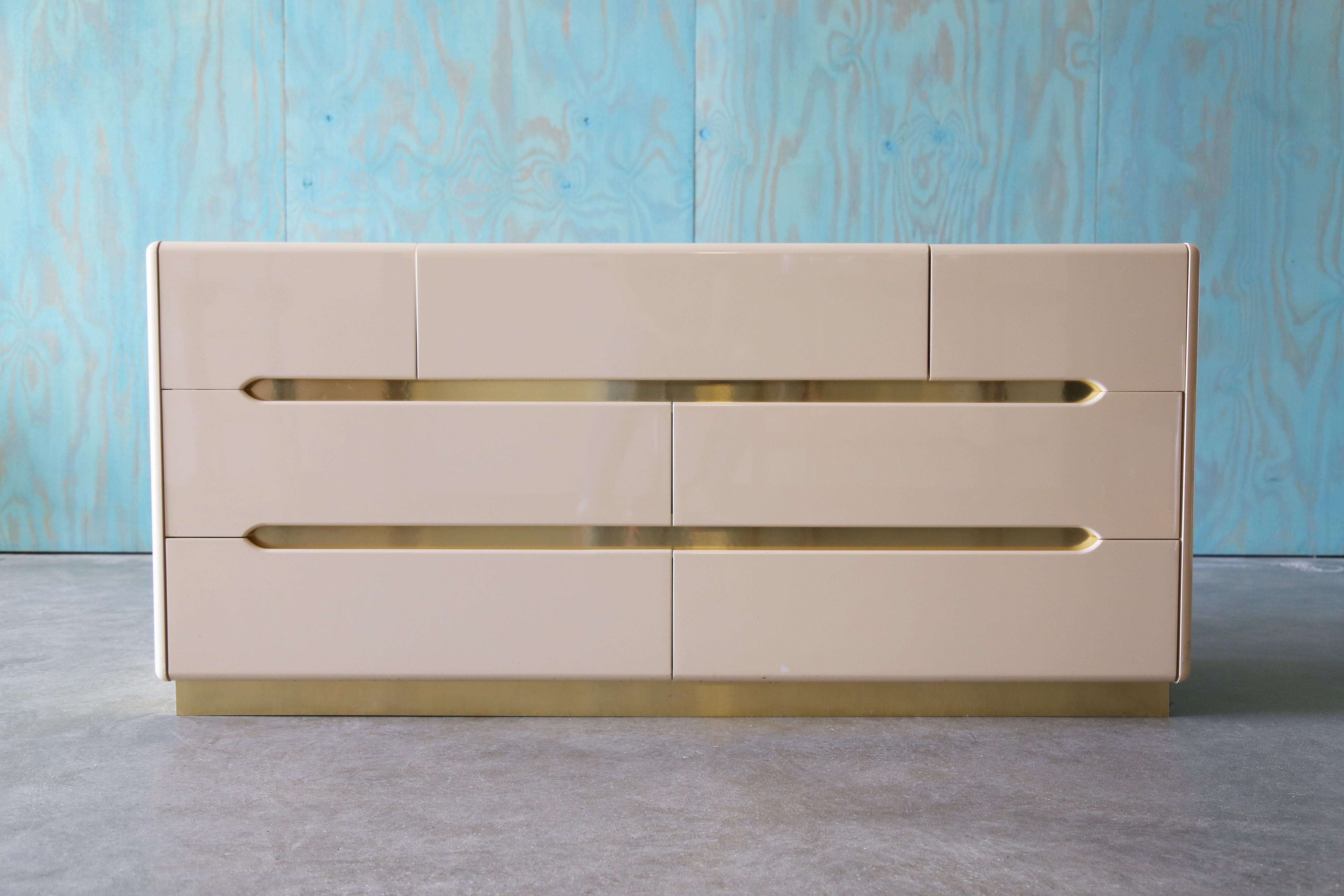 A lacquer and brass dresser marked F. Ili Tomassini Pesaro Made in Italy. However an internet search shows these as being manufactured by Lane.  It is possible Lane was having these made overseas and never rebranded these.    Great space age post