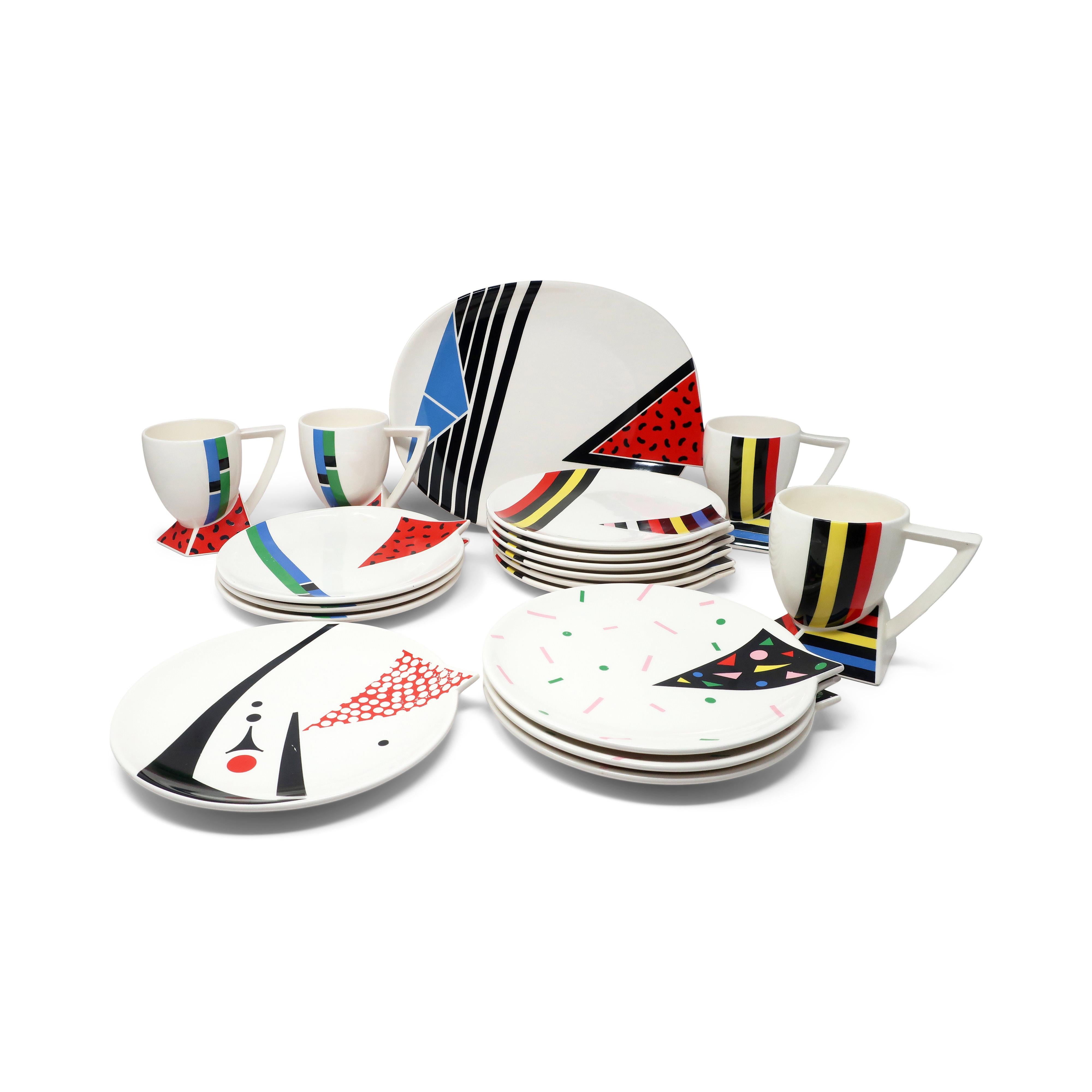 A set of one platter, four mugs and 13 plates in the Alpha 3 pattern for Kato Kogei's Fujimori Collection. As Art Director for Kato Kogei Ceramics, Fujimori oversaw the design and distribution of his signature line. These pieces are perfect 1980s