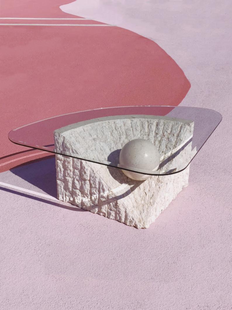 The 1980s Postmodern Stone Mactan coffee table, designed by Magnussen Ponte, is a standout piece that effortlessly combines form and function. With its unique design, this table is sure to become a focal point in any room, drawing attention with its