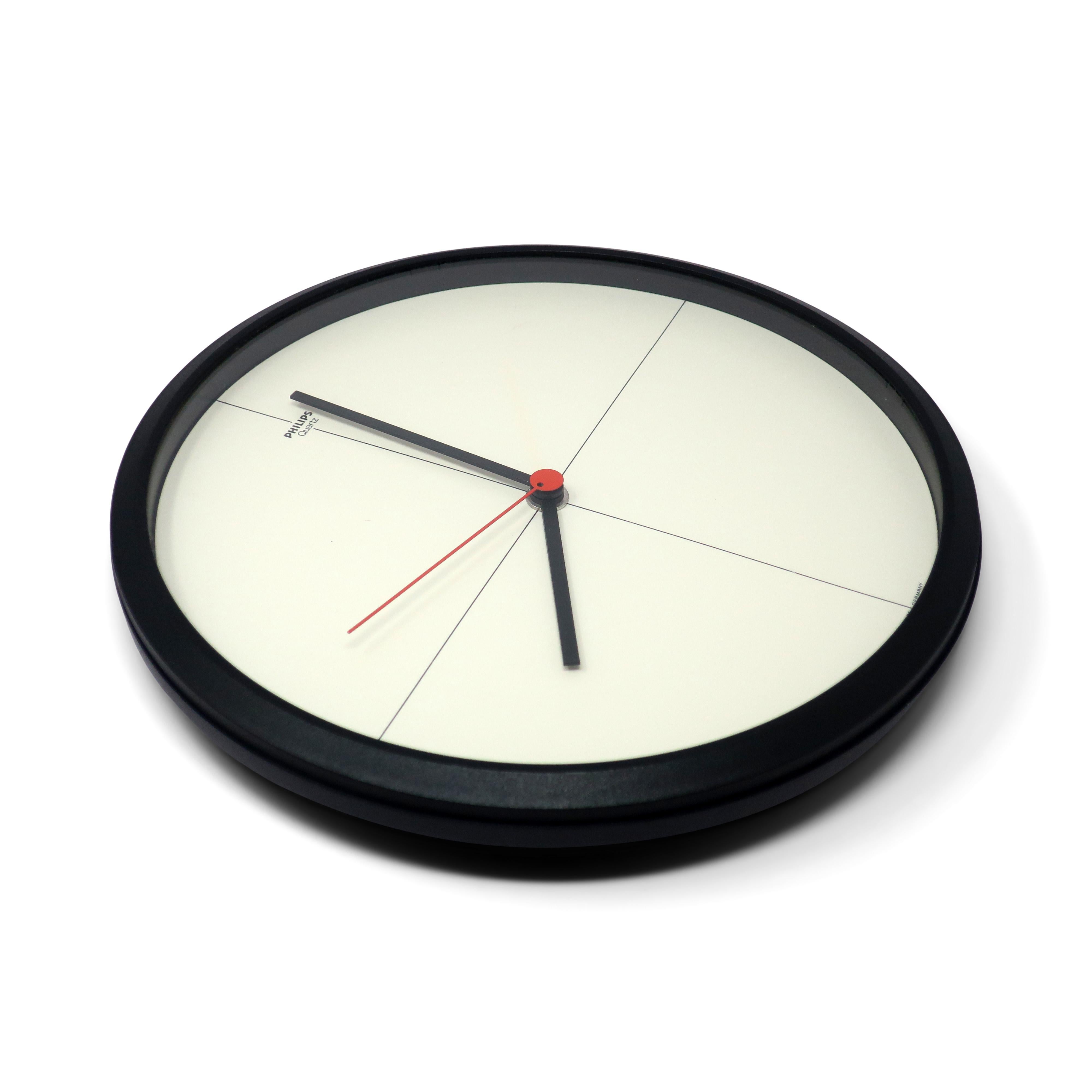 A minimalist postmodern Philips HR 5676 wall clock with all of the best of 1980s design: black case, white face, black and red hands, and a cross through the center point that creates lines at 3, 6, 9, and 12 o'clock. Made in West Germany, so you