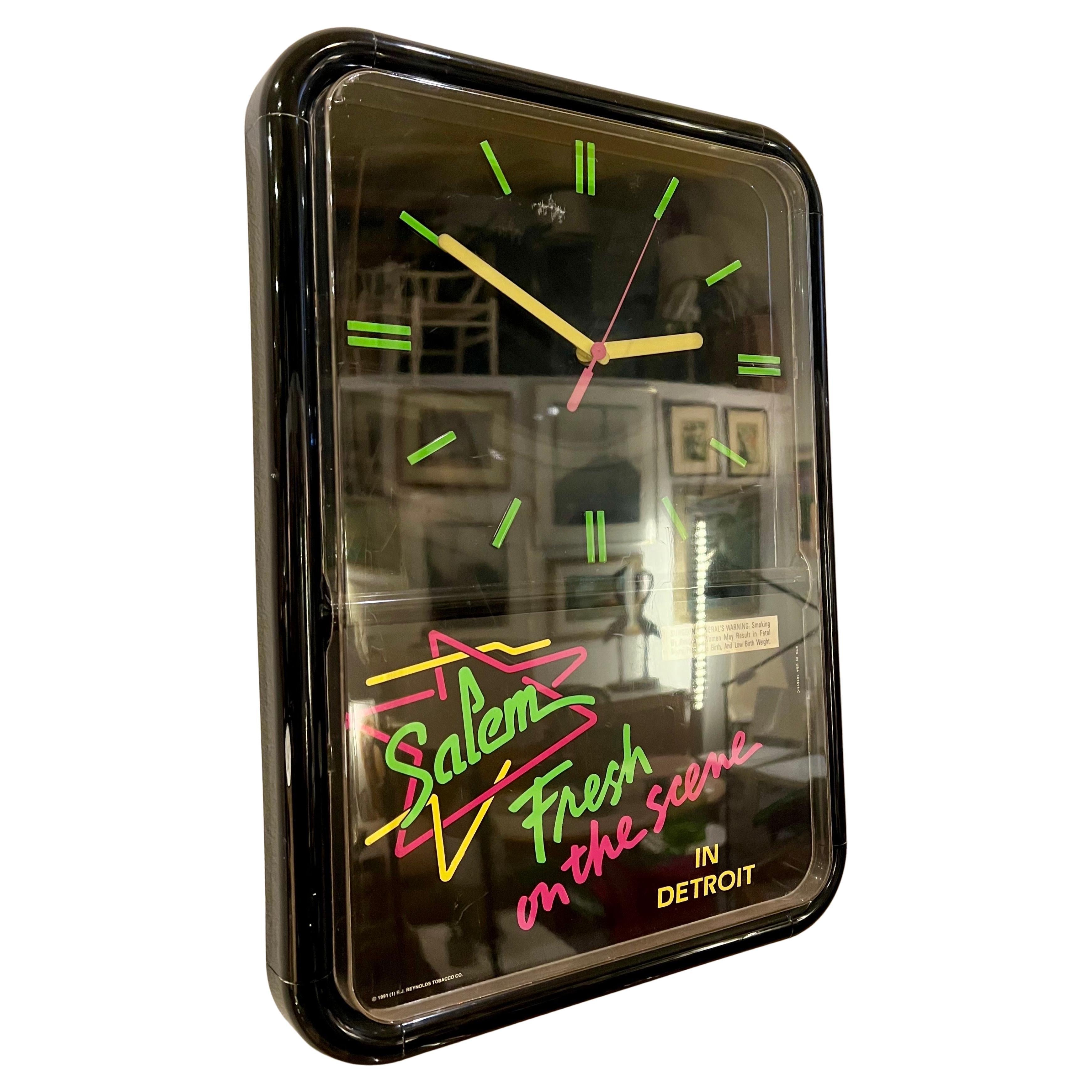 Une horloge murale classique en plastique avec des graphiques en néon, par Salem cigarretes. L'horloge est en bon état et a une pile japonaise.  mouvement, pas de fissures sur le boîtier juste quelques légères rayures sur le plastique transparent