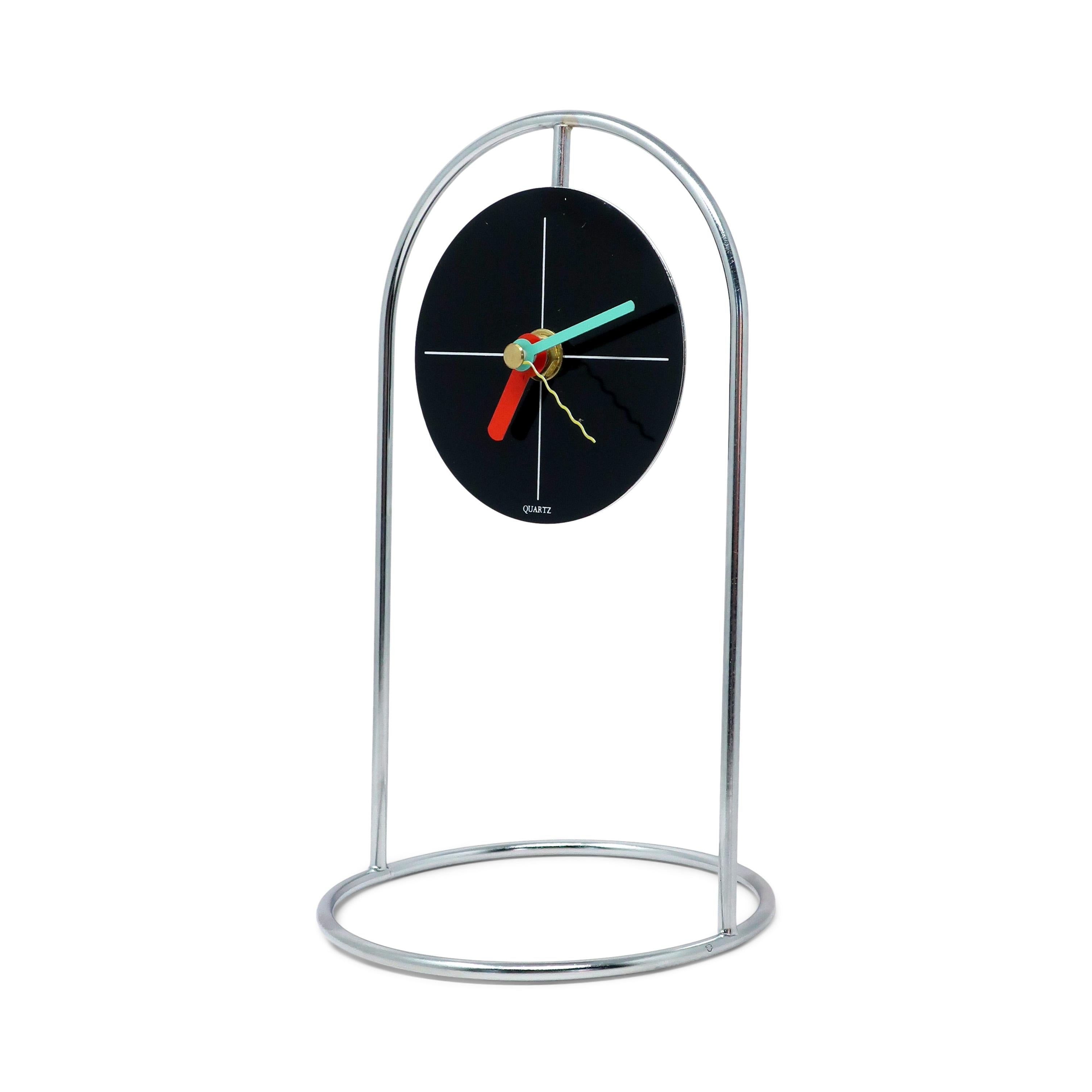Con la sua struttura cromata, il quadrante bianco e nero e le lancette geometriche in verde, rosso e giallo, questo fantastico orologio da tavolo degli anni '80 ha tutte le caratteristiche del grande design postmoderno ispirato a Memphis.  Non