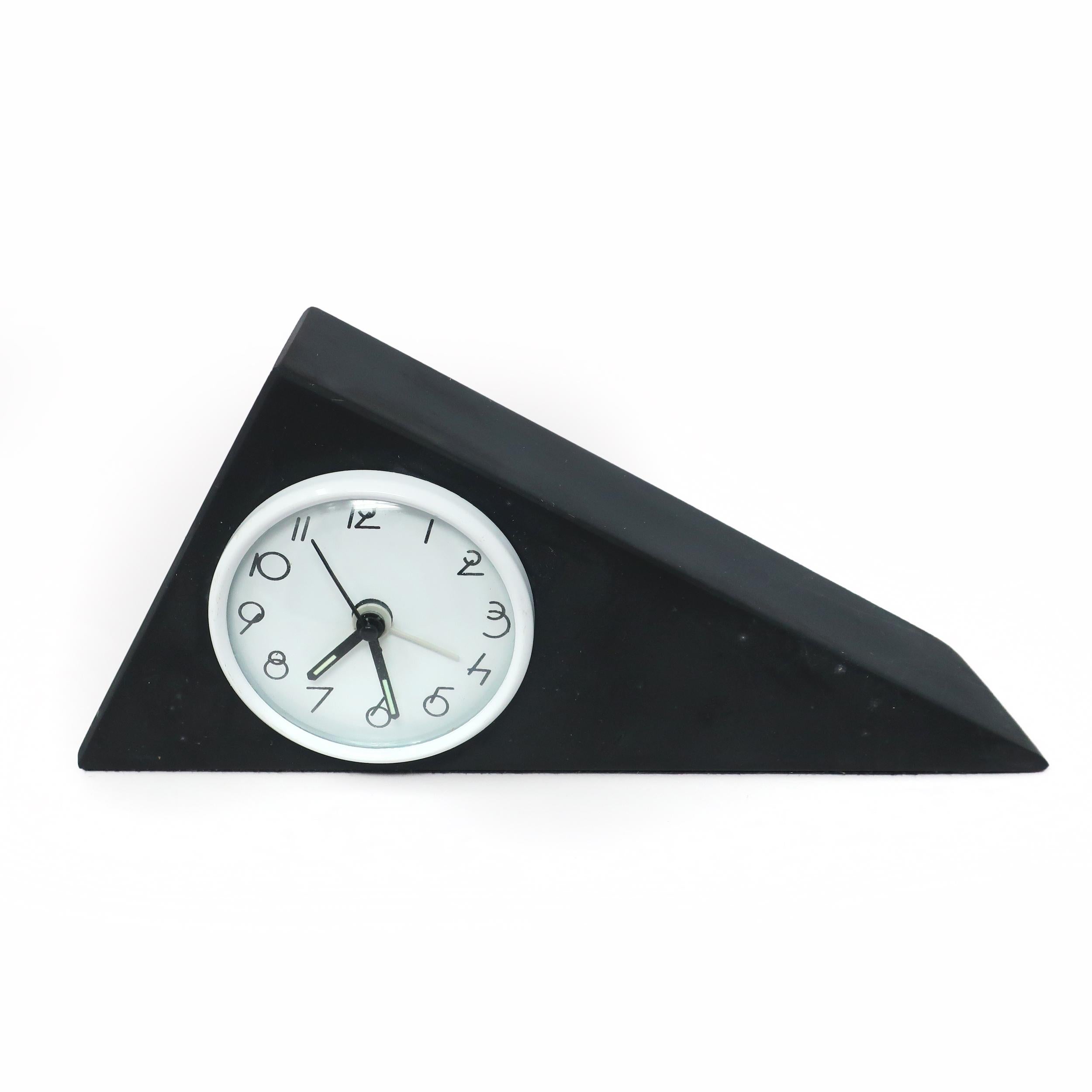 A stunning Italian slate desk clock in the shape of a triangle with black hands, white face, black hands, and stylized Art Deco numbers. Lovely coloring and veining in the slate give it a sophisticated yet natural look.

In good vintage condition.