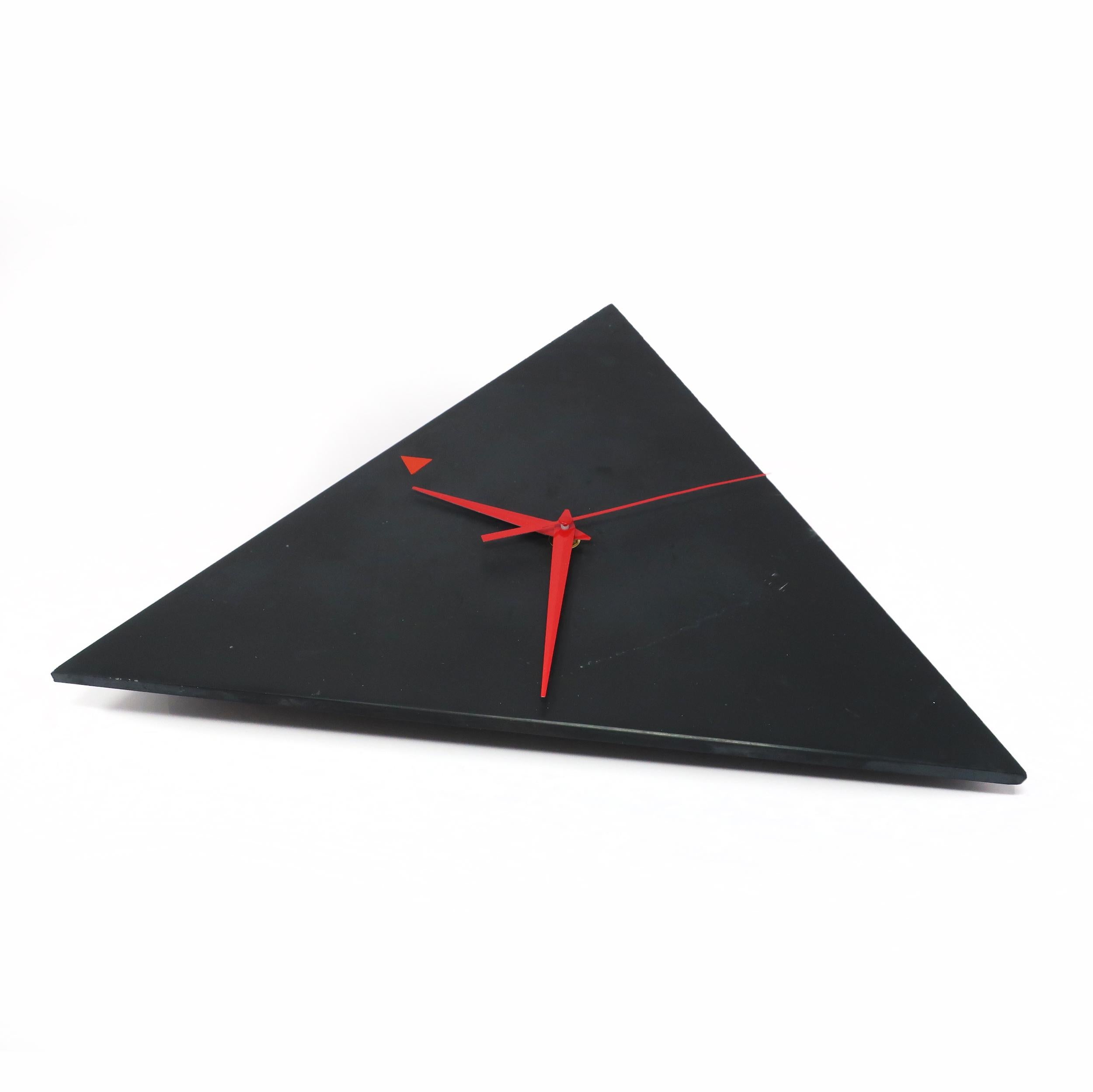 A stunning Italian slate wall clock in the shape of a triangle with red hands and a red triangle at 12 o'clock. Lovely coloring and veining in the slate give it a sophisticated yet natural look.

In good vintage condition. Takes a single AA
