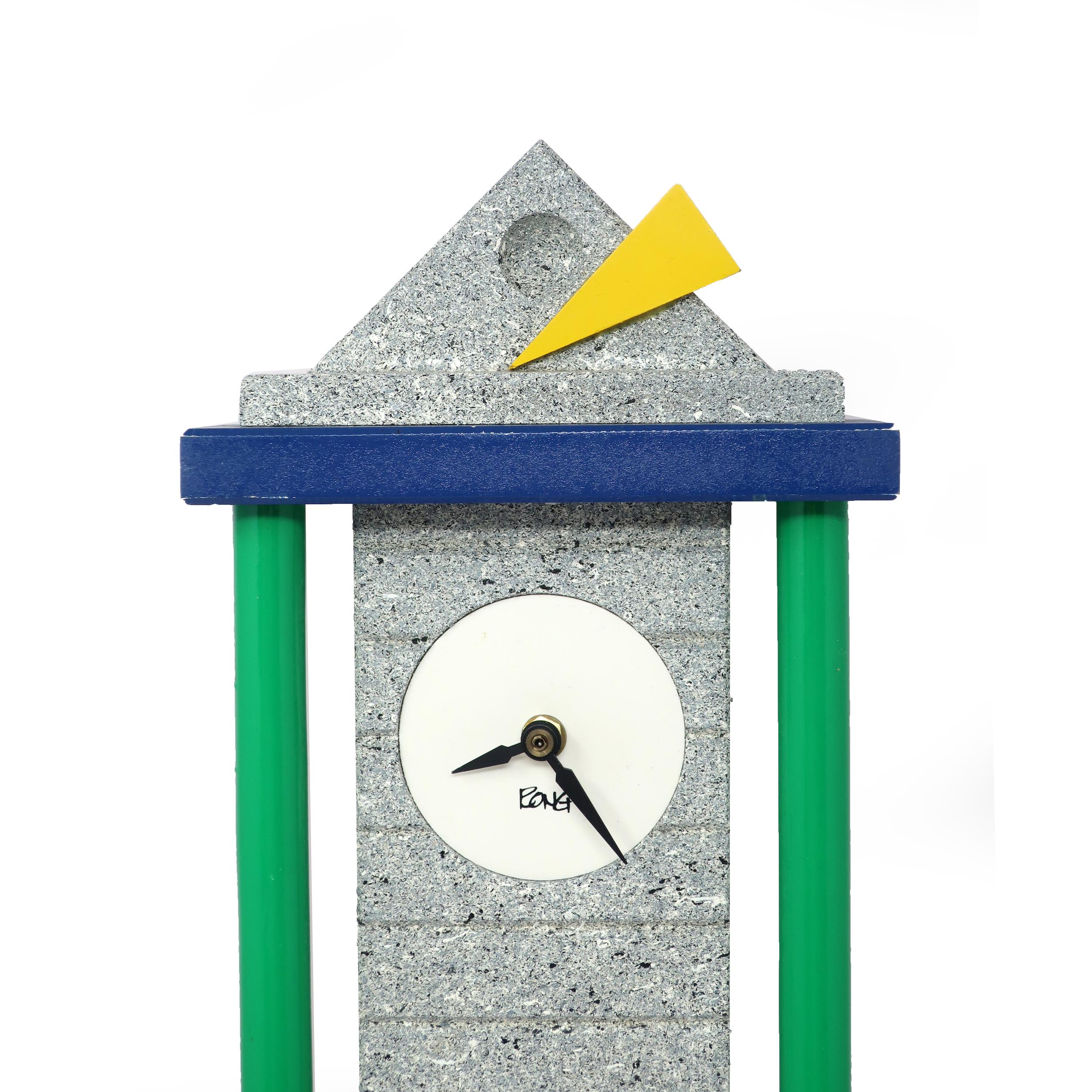 A tall and slim postmodern wall clock with green column, stone textured top and base, white face, black hands, and blue, yellow and red accents. A unique and delightful clock!

In good vintage condition with wear consistent with age and use.