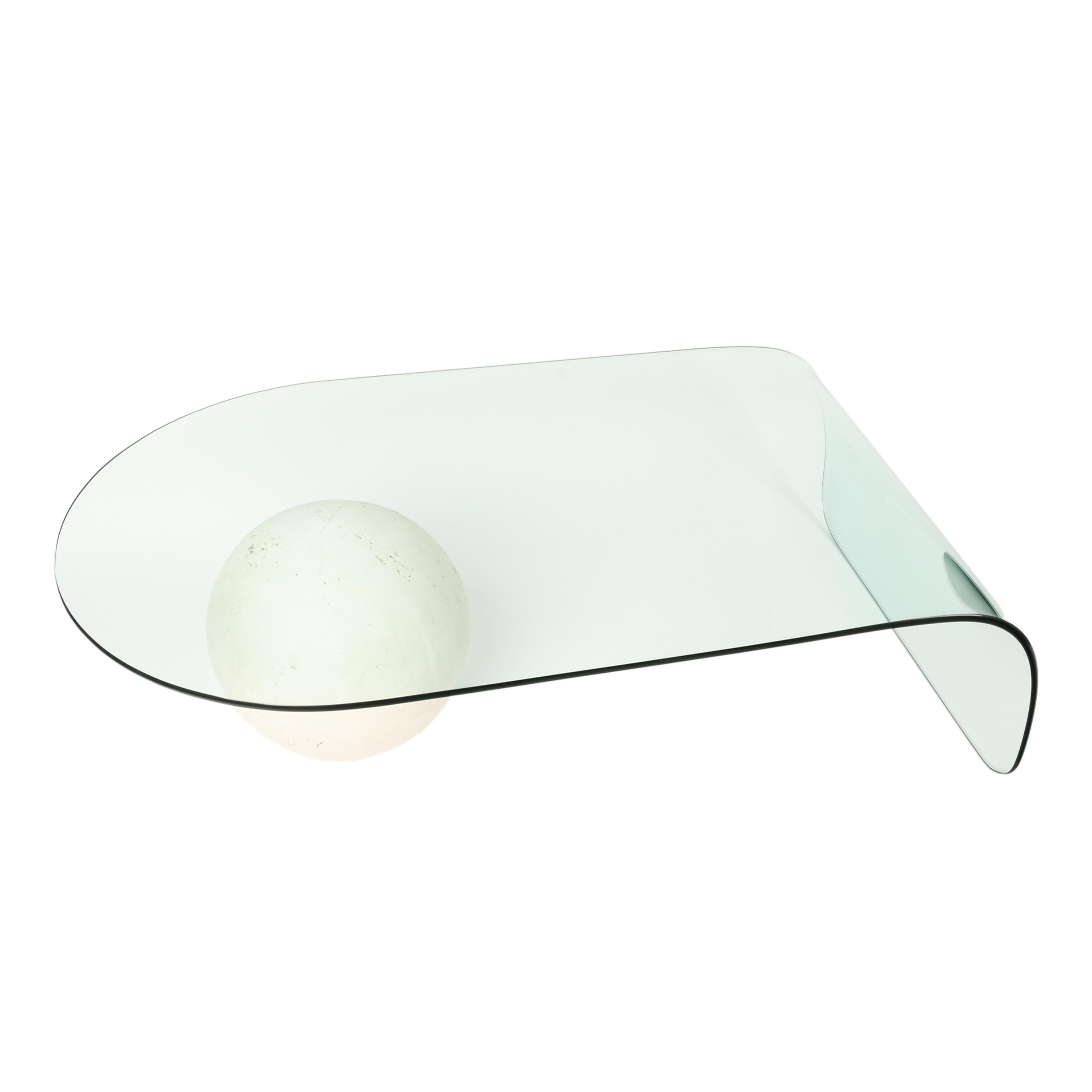 A tempered glass waterfall 1980s coffee table.
A very stylish 1980s coffee table made of tempered glass and supported by a textured plaster sphere. 
Blondie or Depeche Mode are on the radio and you are placing your cocktail glass on this great