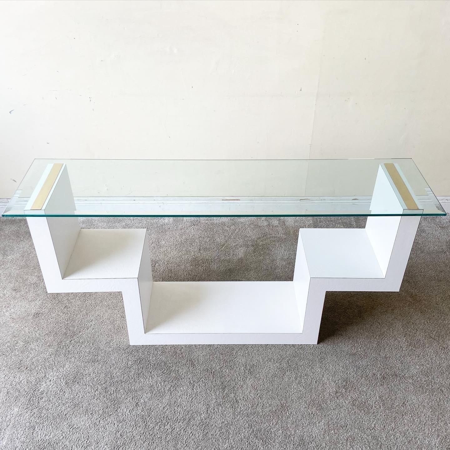 Amazing postmodern beveled glass top console table. Tables features a white faux leather laminate with gold strips on the top of the table base.
