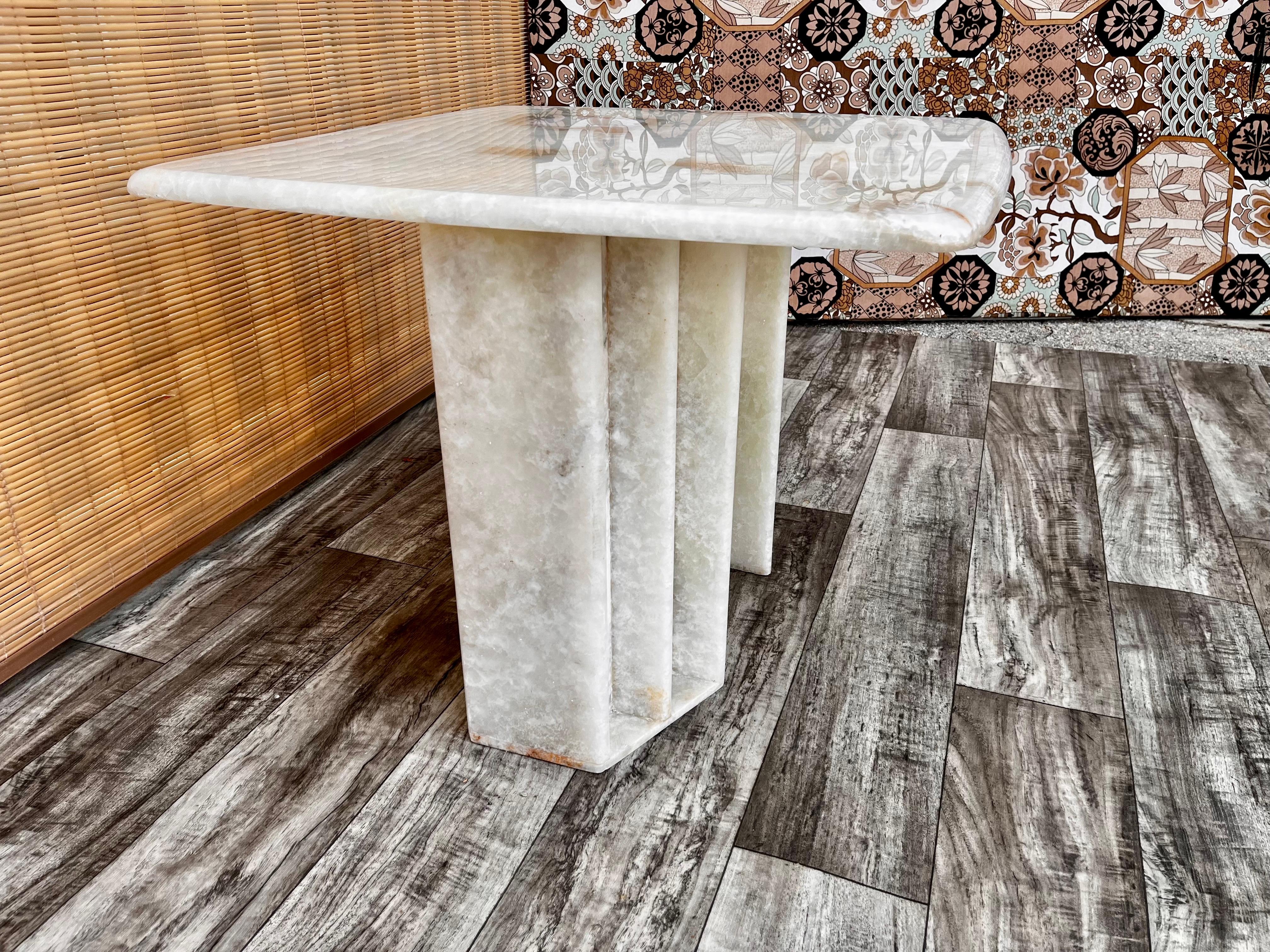 Postmodern White onyx marble occasional side table. circa 1980s
Features a nicely curved border at edges and a gorgeous translucent natural white onyx marble with a white icy background and veins of golds, tan, and grays.
The base can be used in