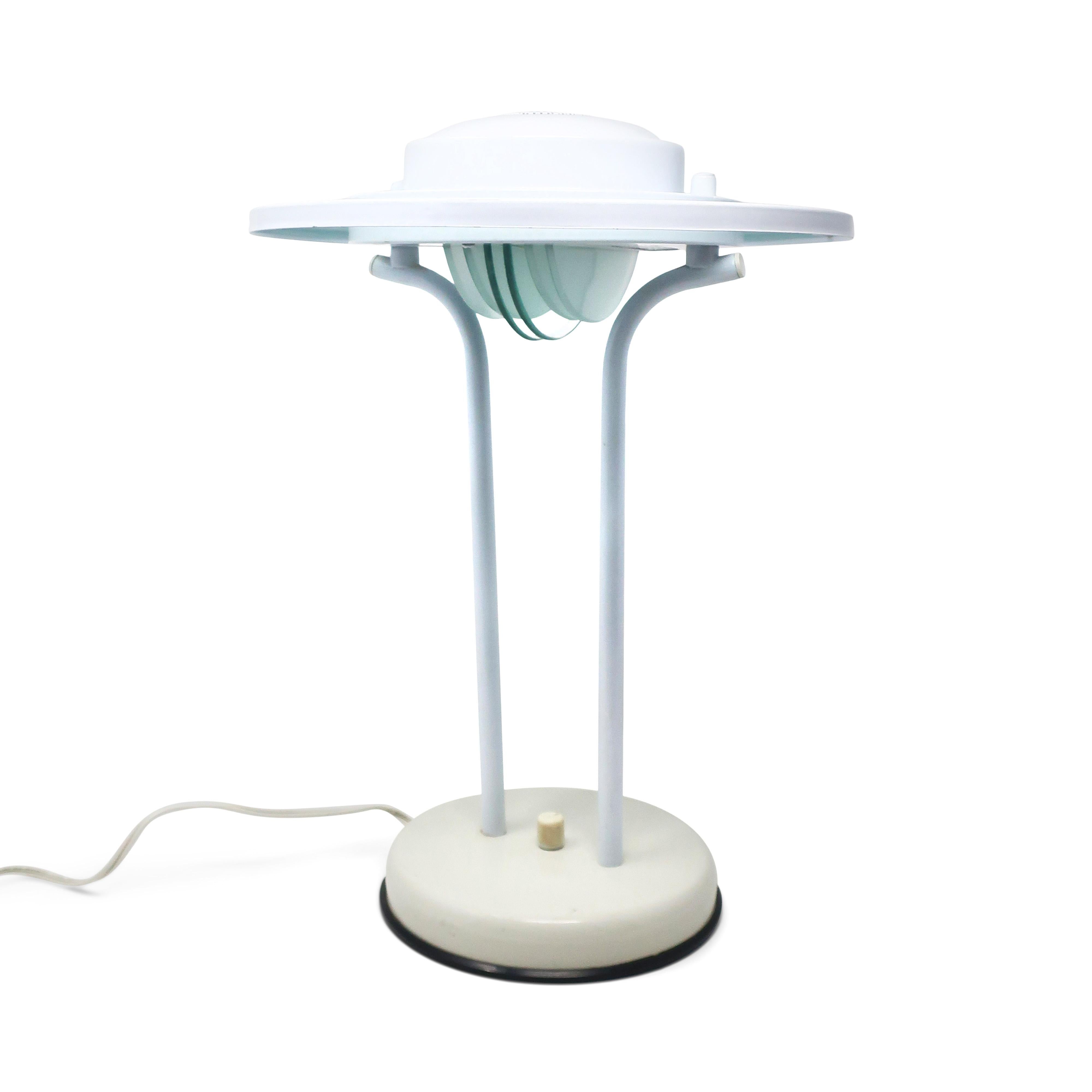 A lovely postmodern flying saucer table lamp by Nadair, a Canadian lighting company, in the style of Robert Sonneman and George Kovacs. White enamled metal base, upright supports, and shade, half circle glass accents hanging below the bulb and a