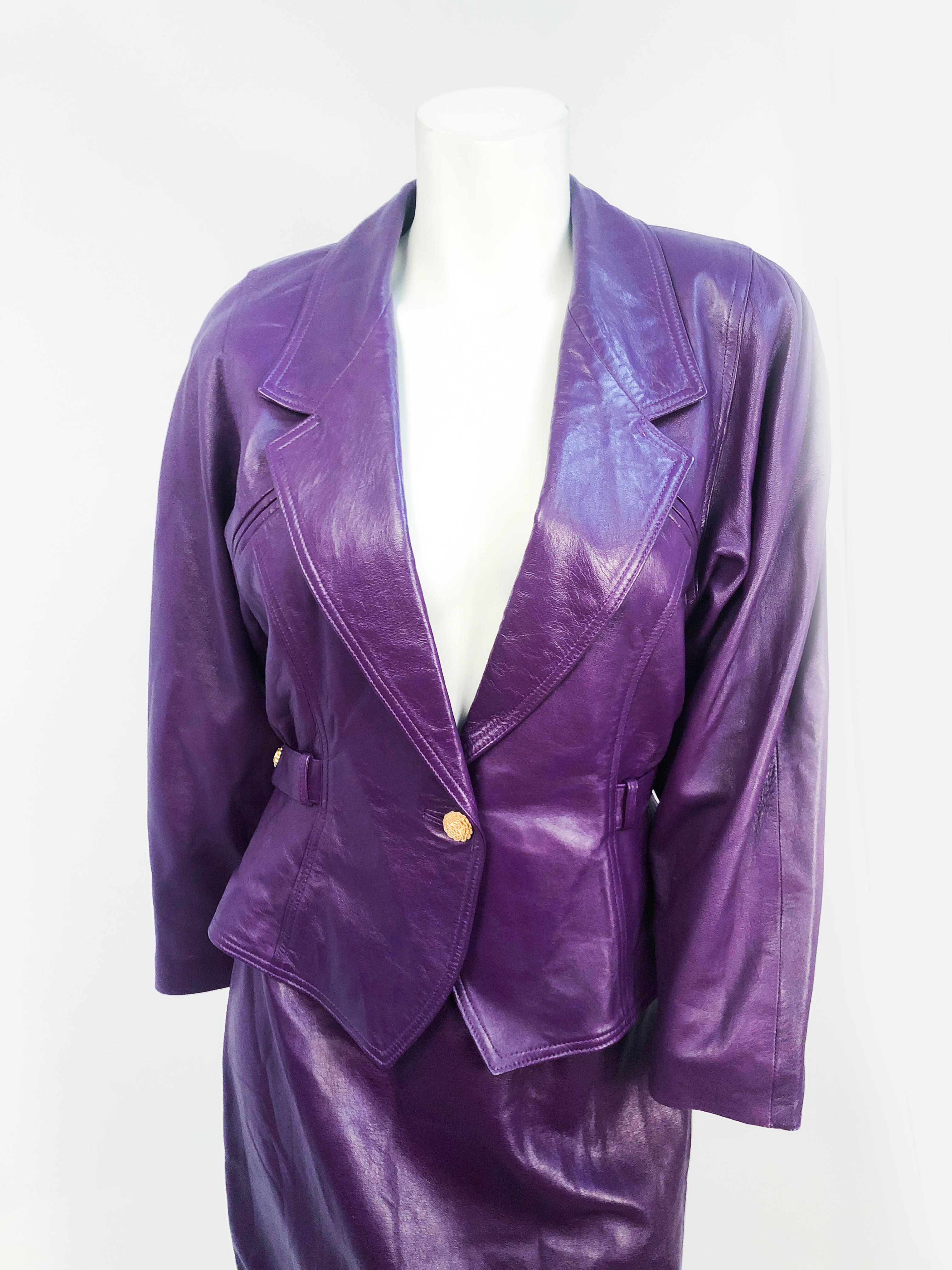 1980s Purple Leather Suit with brass decorative buttons and belted sides. 