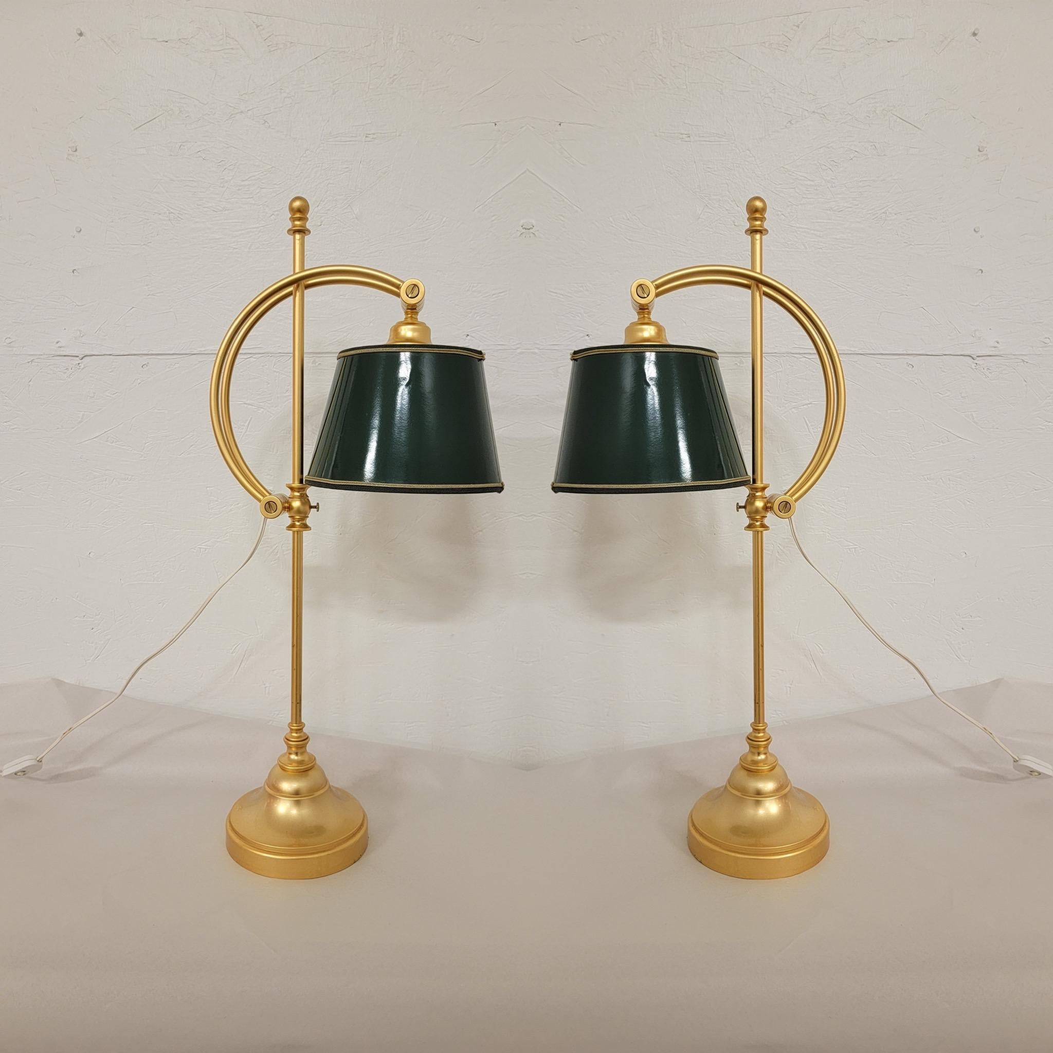 This is a pair of classically style gilt metal table or desk lamps. The shades are a glossy green. One has some damage. They are otherwise in very good condition and unmarked.