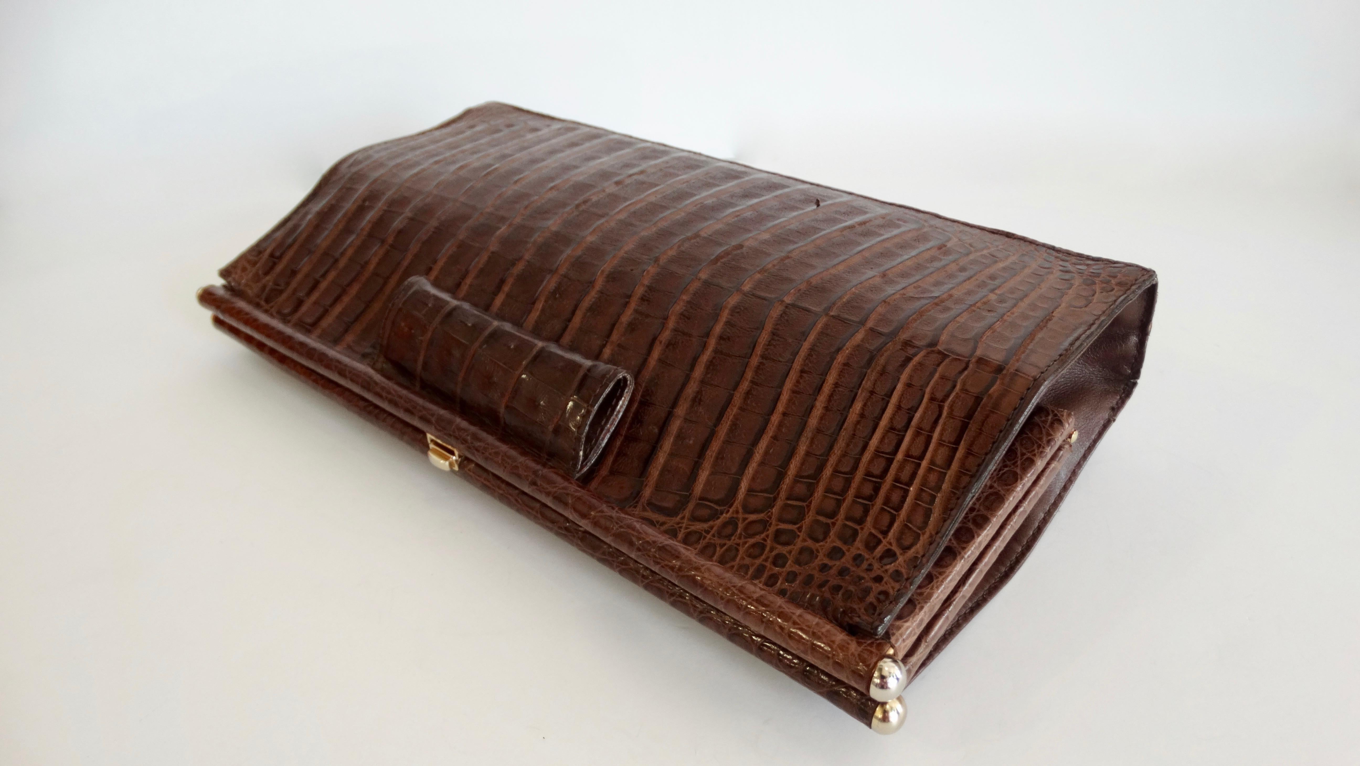 Elevate your purse collection with this Donna Karan clutch! Circa 1980s, this rare clutch is made of genuine caiman crocodile. Features a simple and timeless design and includes a push tap closure. Interior is fully lined in black suede. The perfect
