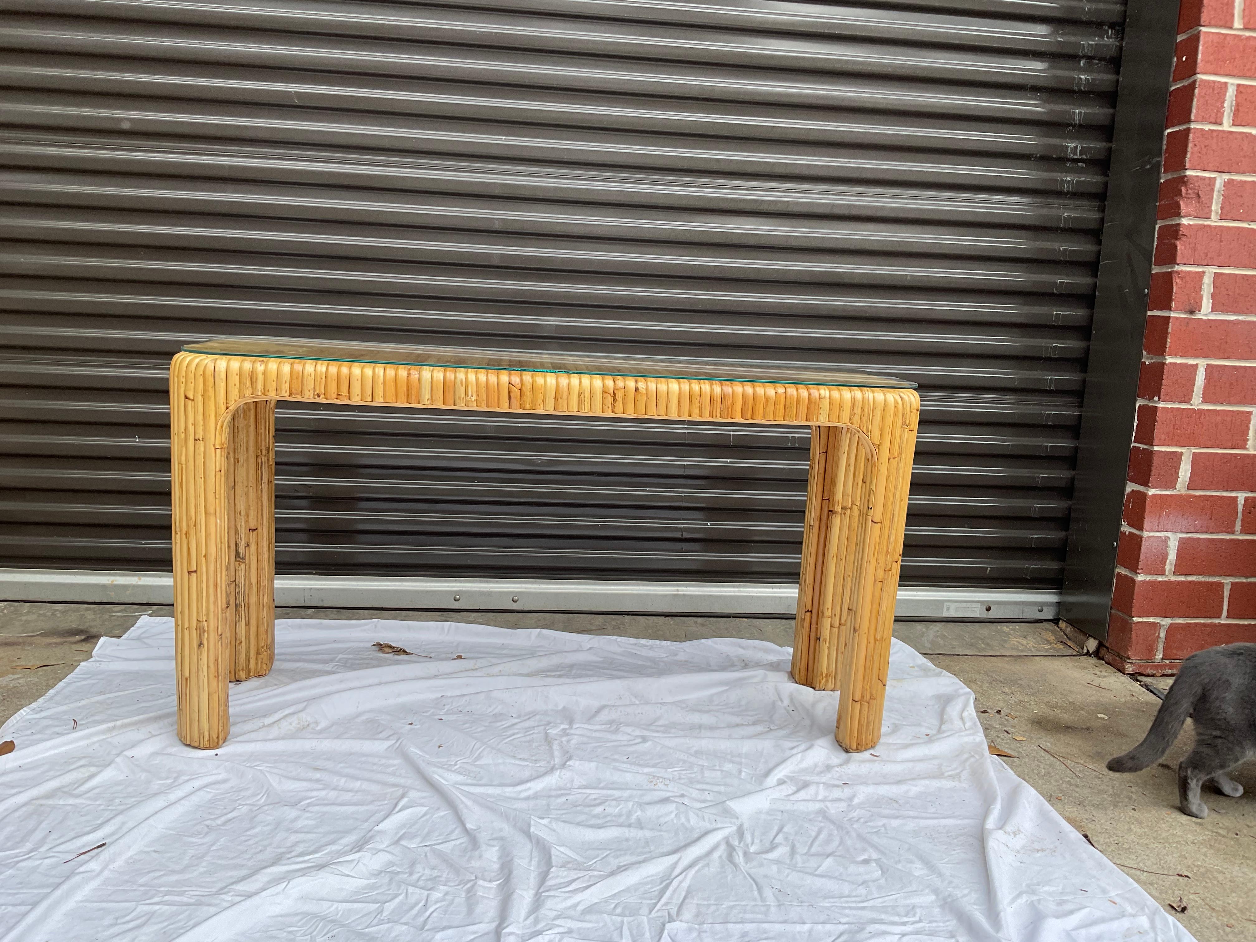 Classic split/ reed rattan console table, with a waterfall style. Custom glass top is included. Could be used with any number of decor styles.