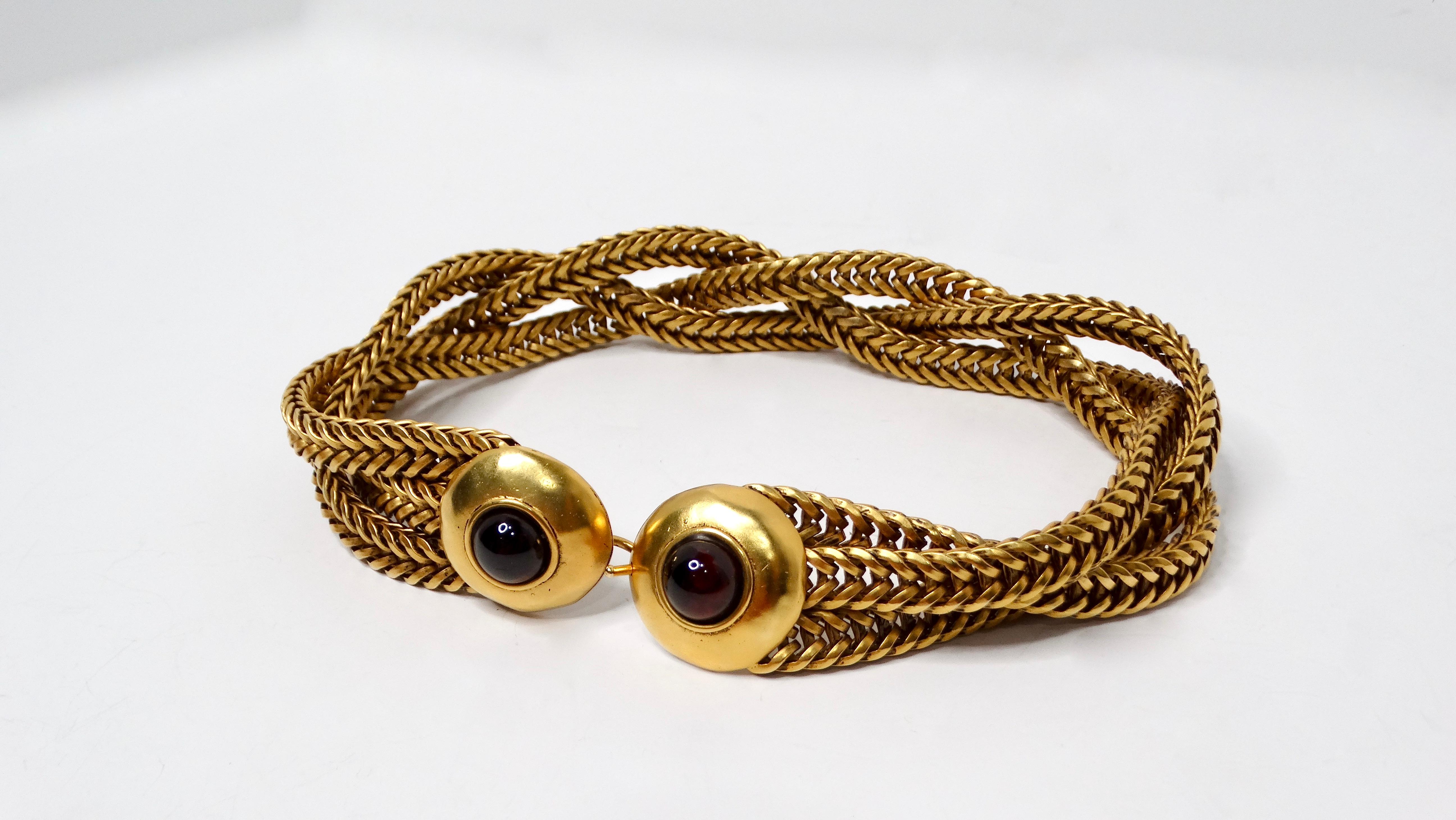 Torna alla moda vivace degli anni '80 con questa splendida collana a girocollo con cabochon rossi e catene multiple in tonalità oro. Questo splendido pezzo mette in mostra un audace cabochon rosso, circondato da una lussuosa catena dorata,