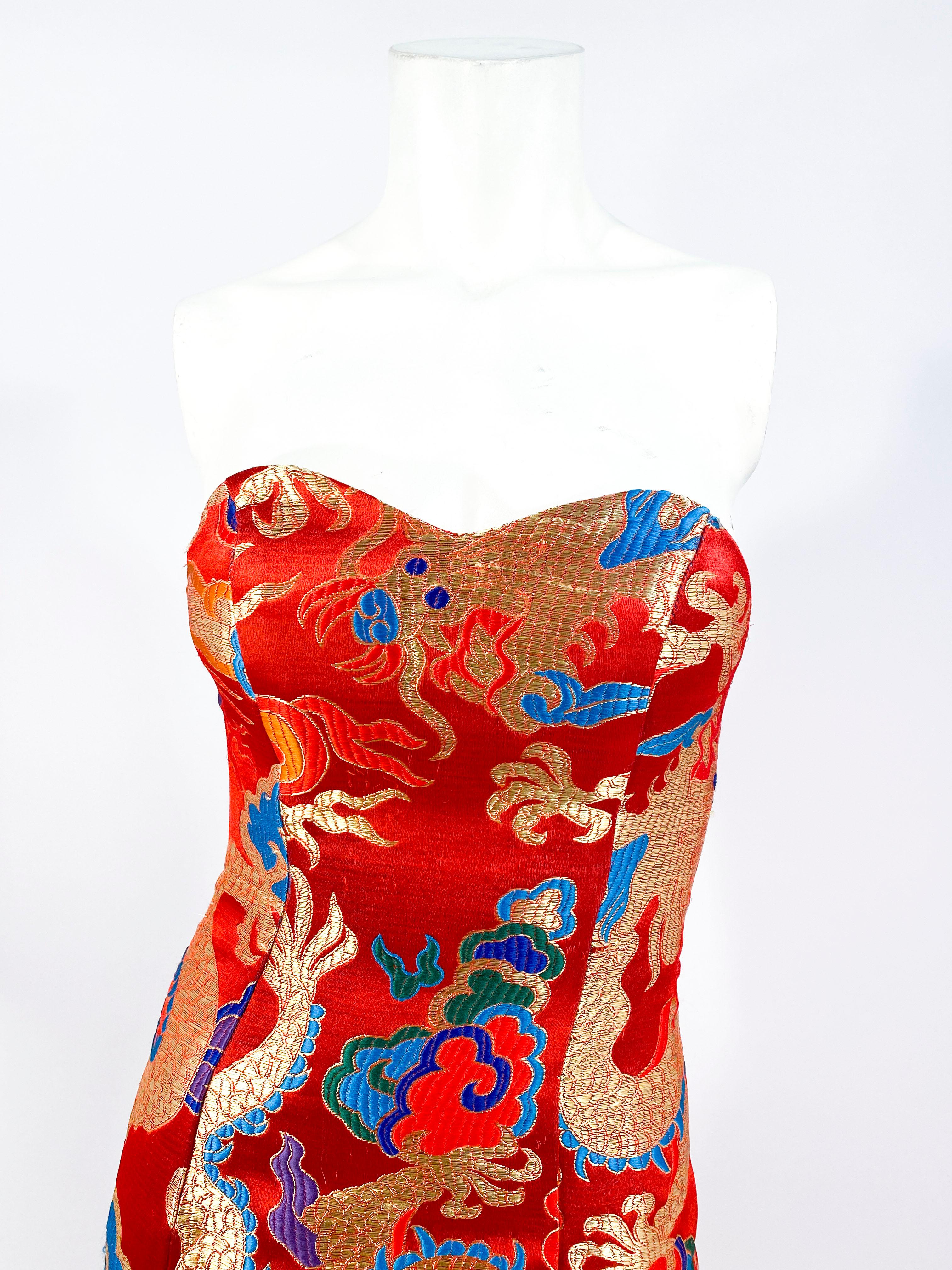 1980s custom made strapless gown with fishtail and train. Made of vintage kimono fabric in red featuring a brilliant gold dragon motif with jewel-tone accents. The bodice is sculpted for support. The tie-up closure is located on the back of the