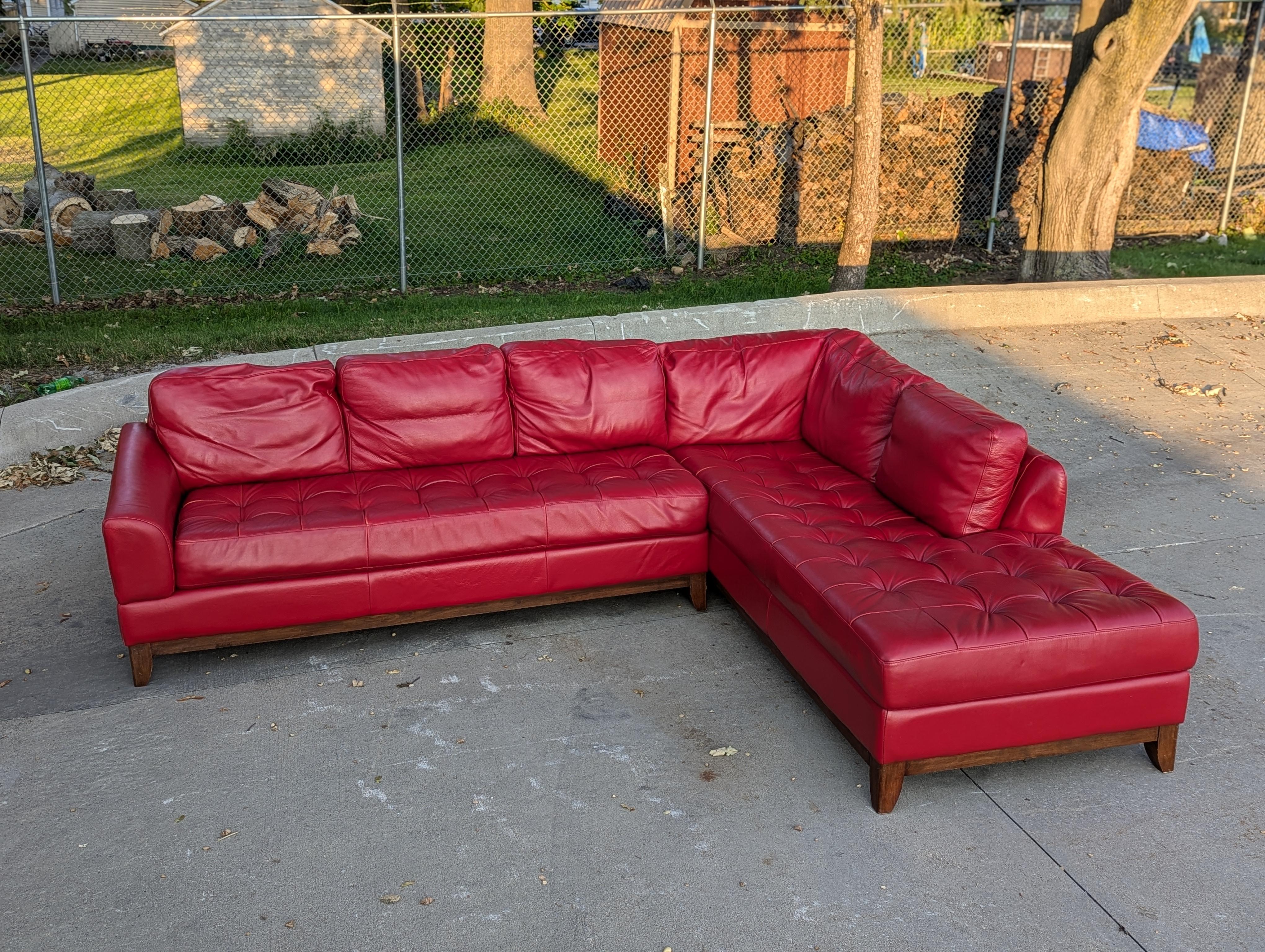 Vintage red leather sectional sofa. 

8 ft wide with extra long 9 ft + chaise lounge.

Quilted or tufted seats with soft padded cushions.

Leather is soft with patina from age.

No markings or tags present, similar to designs by Natuzzi or Roche