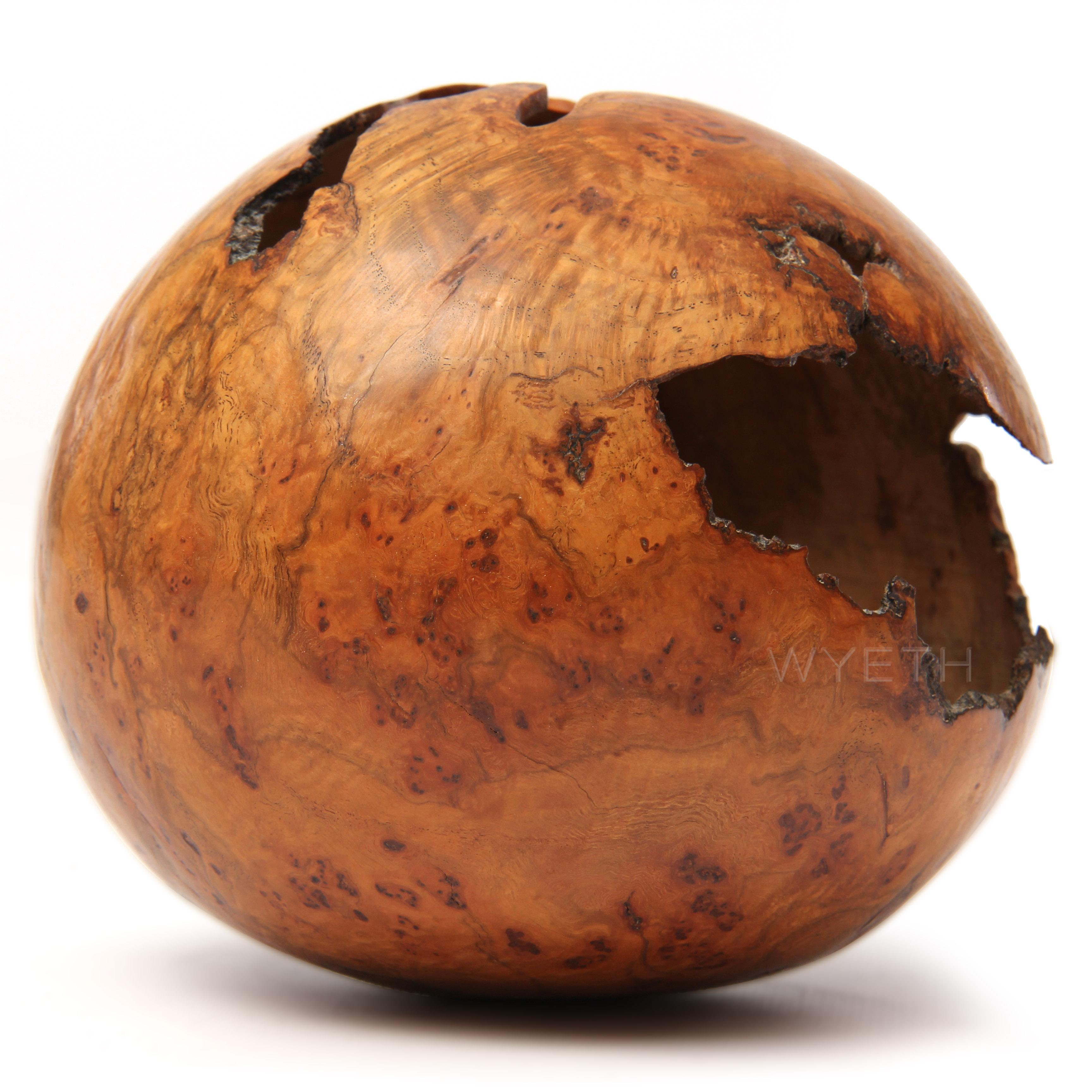 A delicate lathe turned sphere in red oak burl with natural occlusions. Signed 