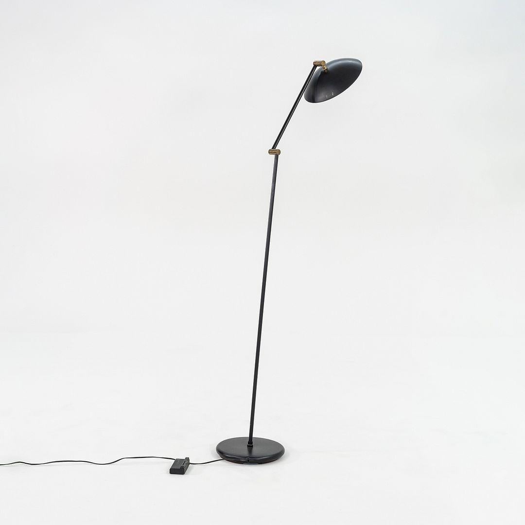 Se trata de una lámpara de pie moderna, fabricada por Relux Milano en Italia en la década de 1980. La pieza tiene una pantalla ajustable de acero negro, y la tija es igualmente negra. La pantalla es móvil y puede dirigir la luz hacia donde apunte, y