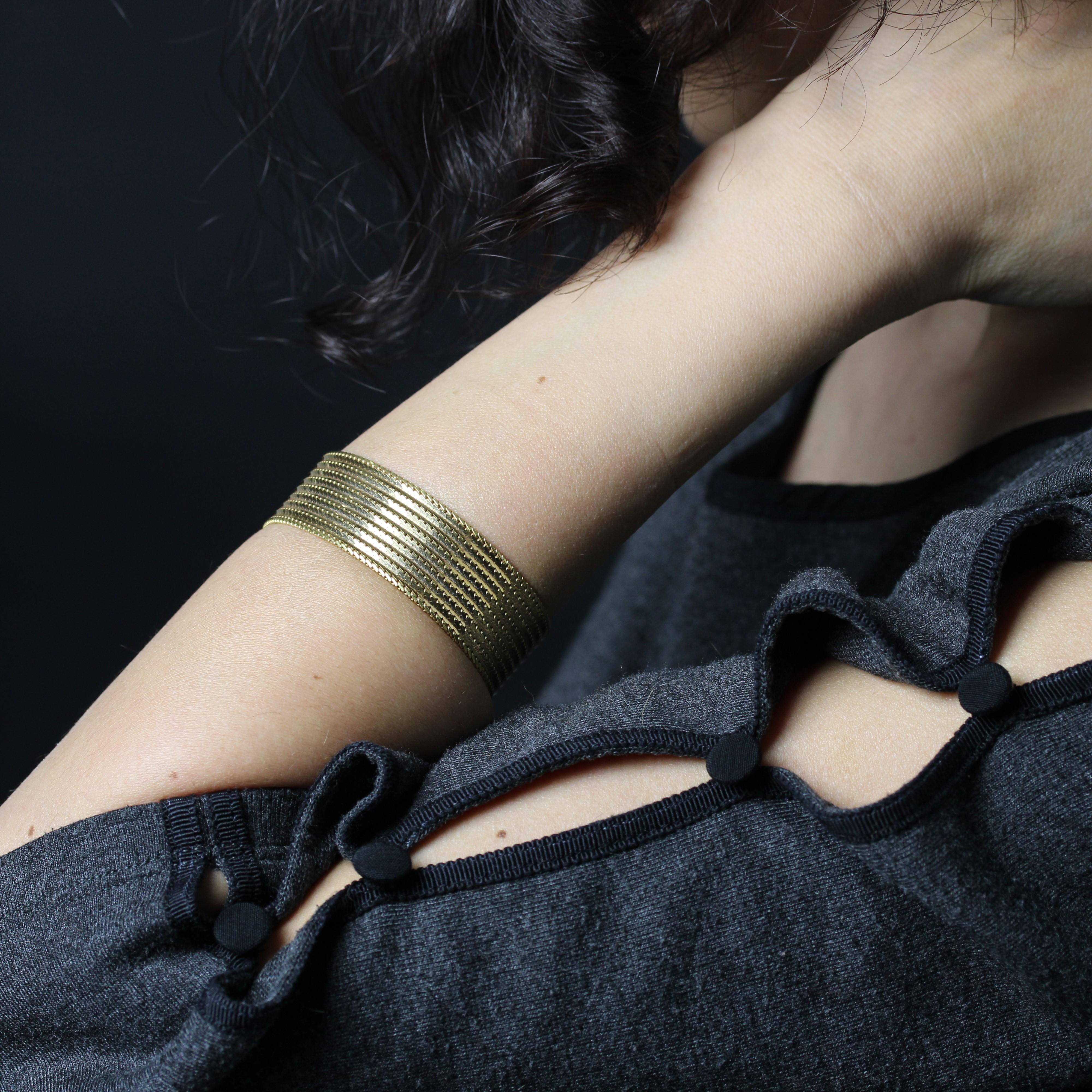 Bracelet in 18 karat yellow gold weevil hallmark. 
A vintage bracelet, it is made of a supple mesh intertwined with gourmette meshes filed at the top. The clasp is a ratchet with 2 safety eights.
Total length : 18.5 cm, width: 1.8 cm, the larger