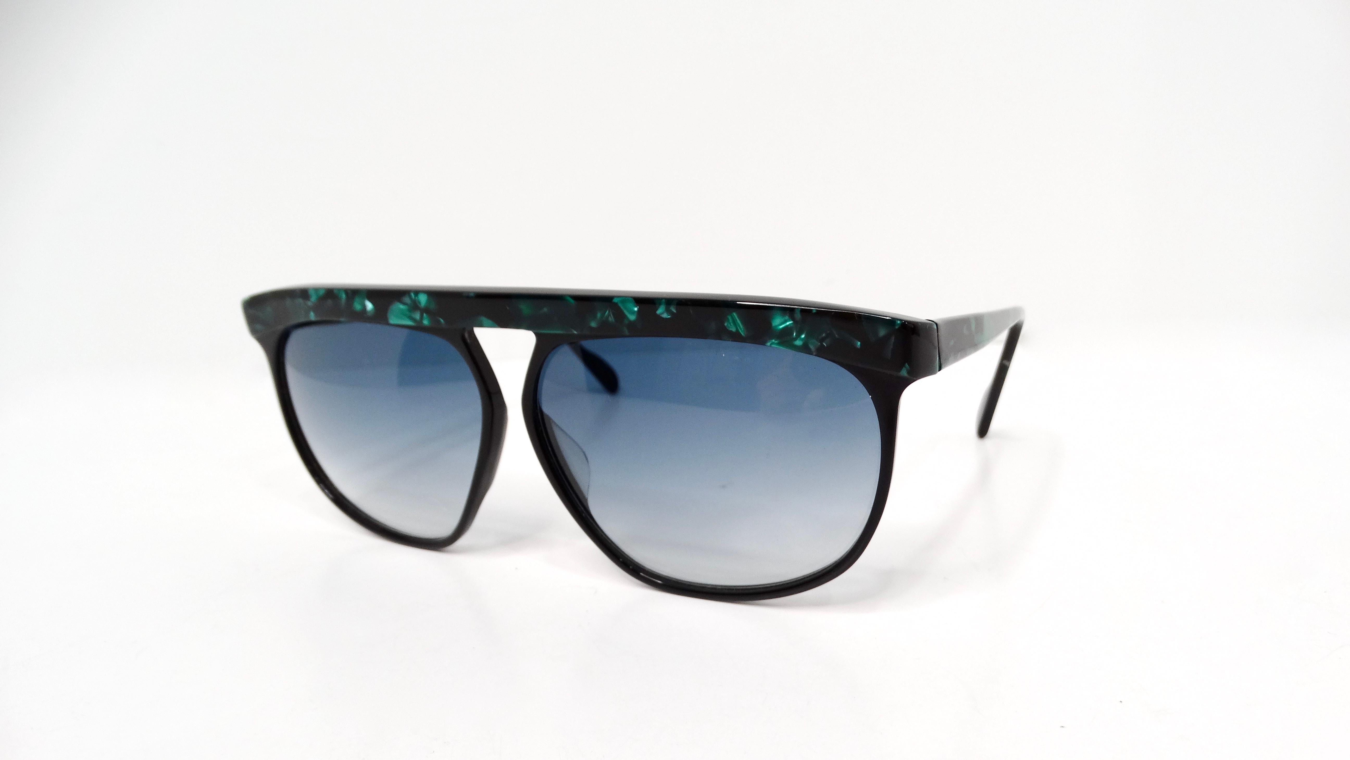 Step into the vibrant world of 1980s retro fashion with these striking black and green marble-style sunglasses. The black base provides a sleek foundation, while the shiny green marble detailing on the top frame bar and sides adds a touch of