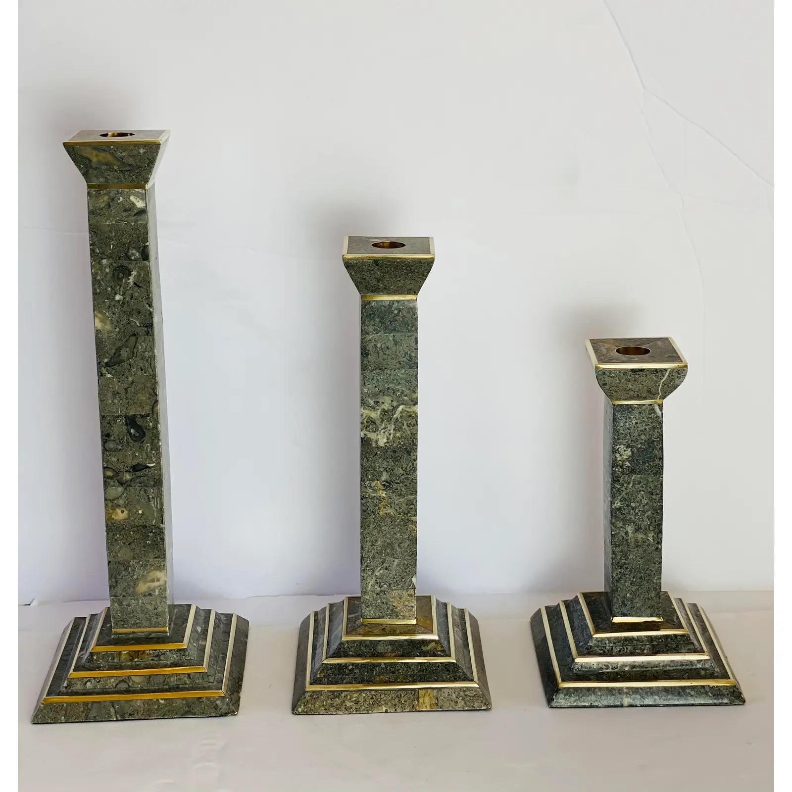 We are very pleased to offer a set of three monumental candlesticks by Robert Marcius for Casa Bisque, circa the 1980s. This sculptural set showcases a grey tessellated stone with inlaid brass accents. In great vintage condition consistent with wear