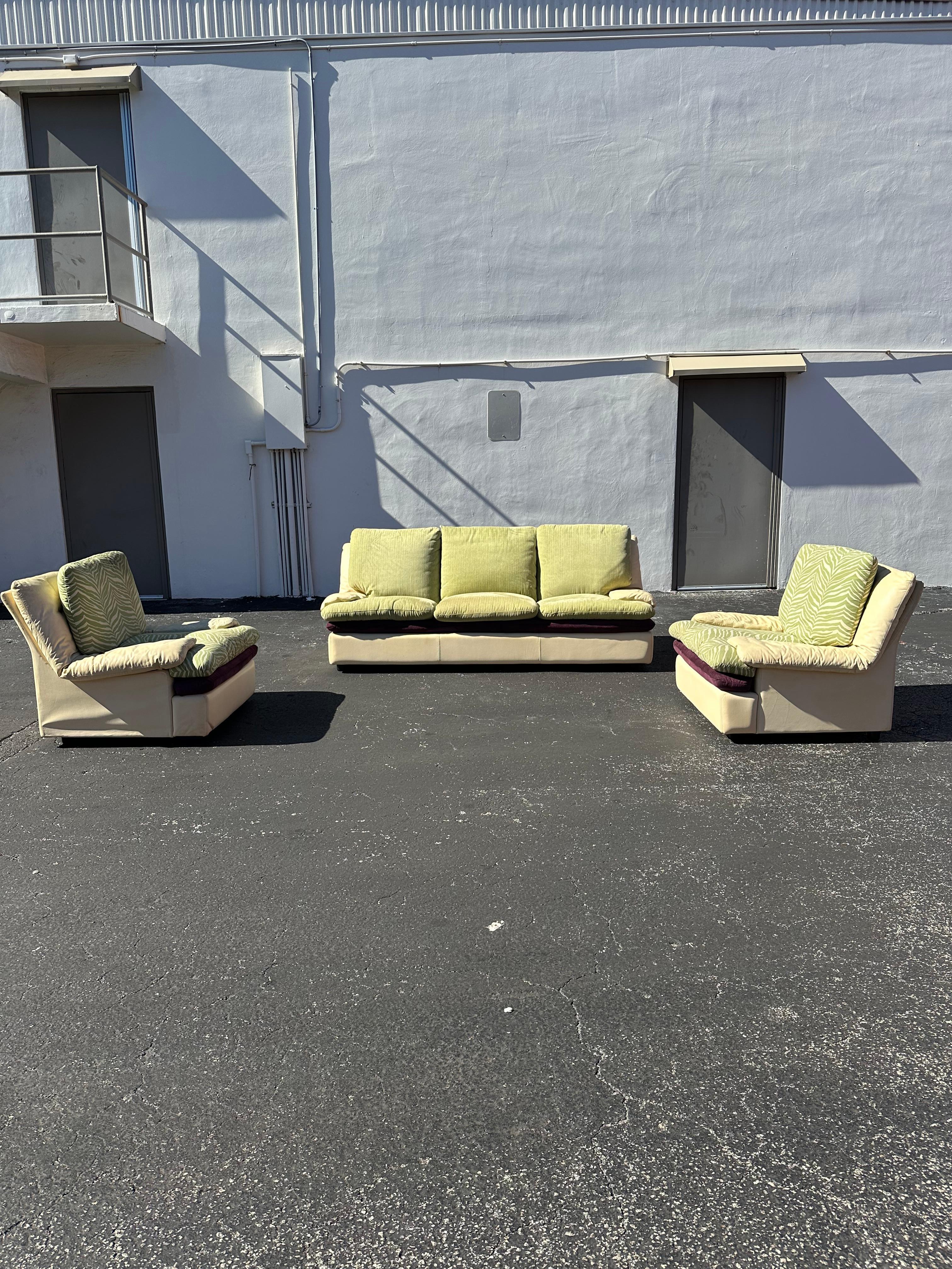 Transport yourself back to the sleek and sophisticated 1980s with this sofa set. The ultra rare set exudes an air of luxury and refinement. Outstanding design is exhibited throughout. The beautiful custom set in beige leather, purple and green