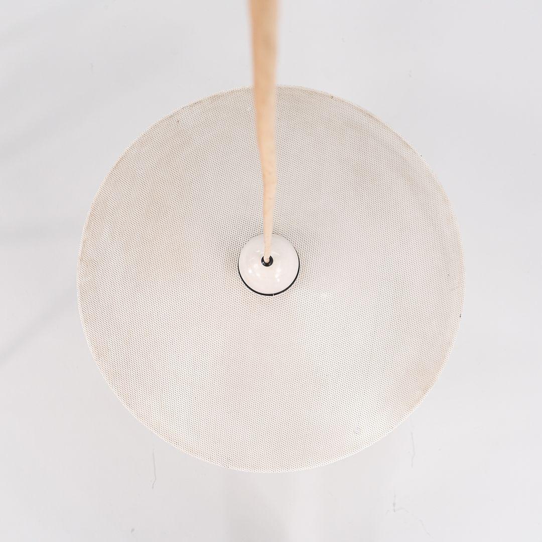 Questa è una lampada a sospensione in metallo perforato in stile Memphis, progettata e prodotta dal designer californiano Ron Rezek all'inizio degli anni '80. Il paralume è realizzato in metallo stampato con centinaia di piccoli fori, che
