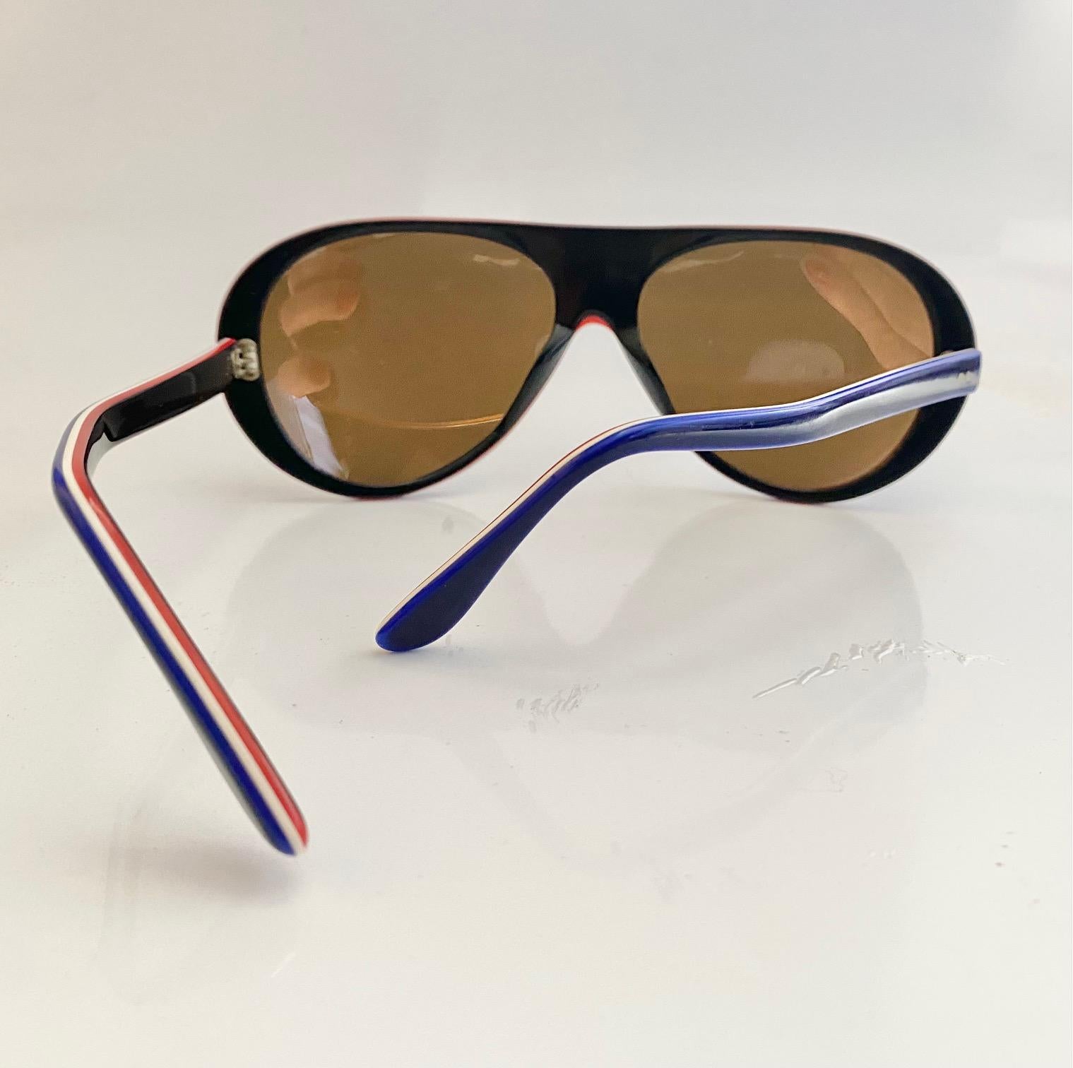 The 1980s Rossignol Mirrored Ski/Beach Blue red White (French flag colors)  Sunglasses boast a bright blue frame, mirrored lenses, and French flag-colored temples, all crafted in France.

Condition: late 70s, early 80s, vintage,