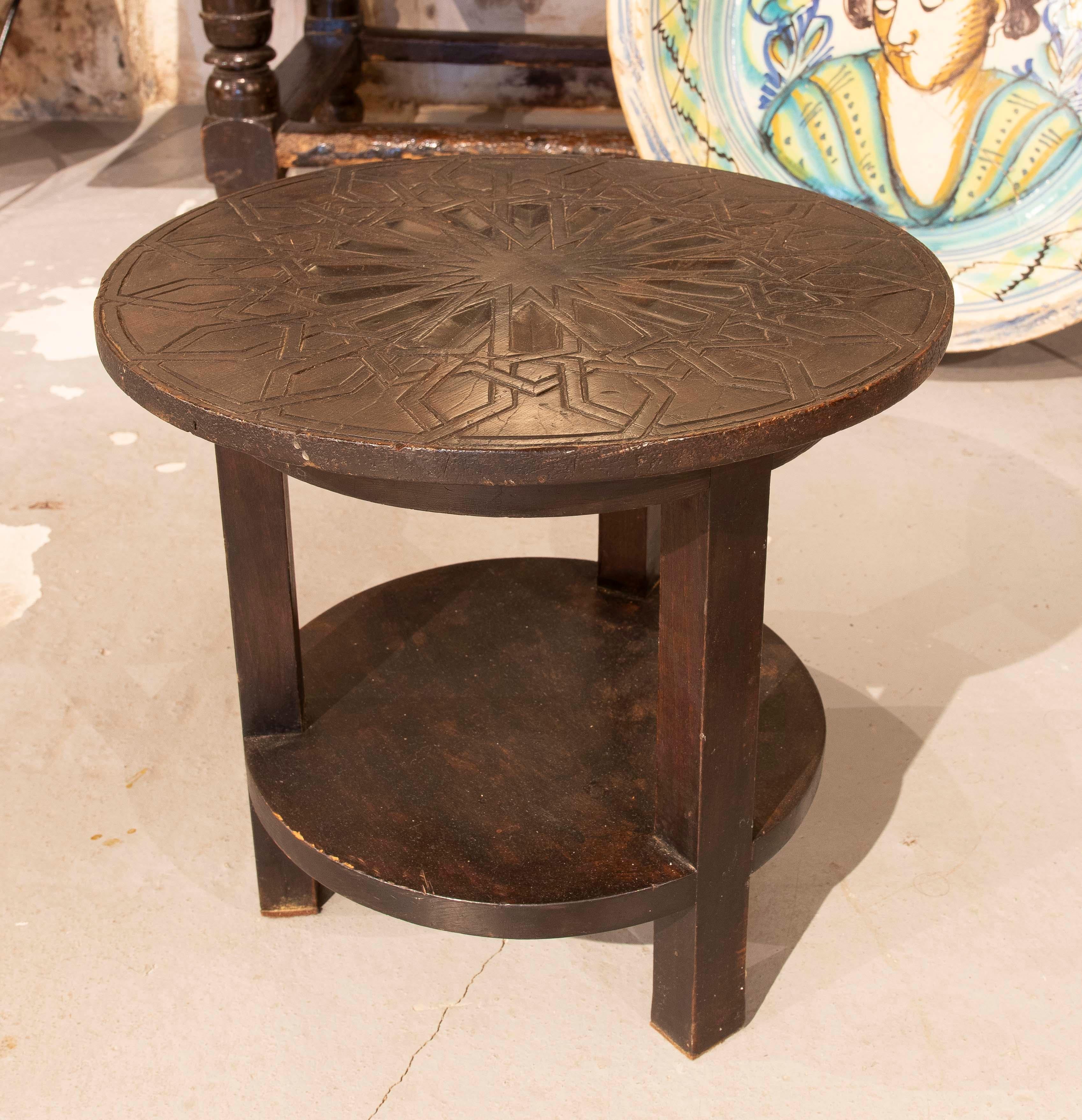 Schöner runder Beistelltisch aus Massivholz mit einer exquisiten geometrischen Gravur auf der Oberfläche, die von traditionellen arabischen Mustern inspiriert ist. Das dunkle Finish hebt die Tiefe der Schnitzereien hervor und sorgt für einen