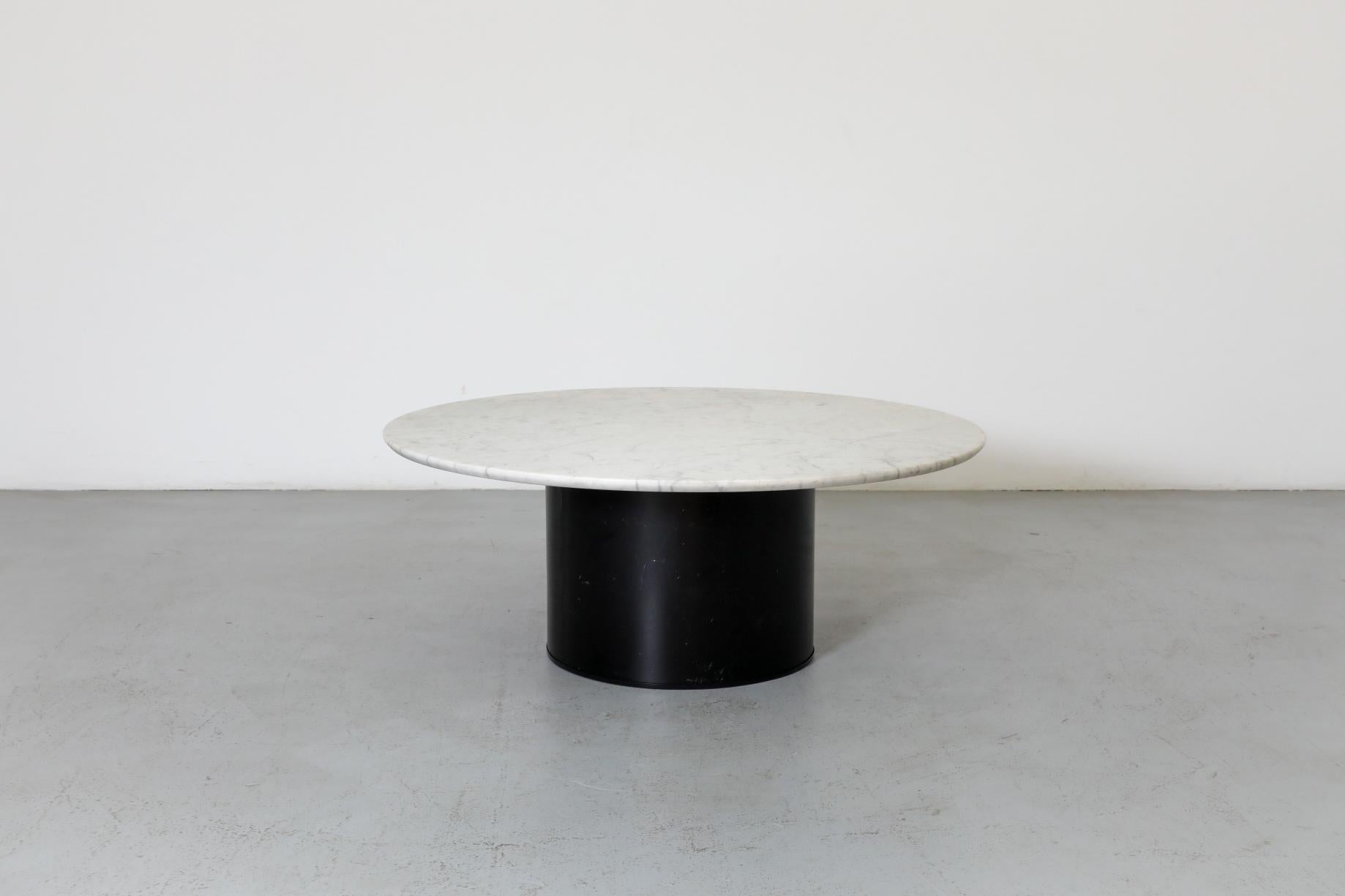 Round 1980's Metaform coffee table with carrara marble top and wide black enameled metal drum base. Top features smooth, reversed bevel edge and deep textural character in whites and grays. In original condition with visible wear and scratches