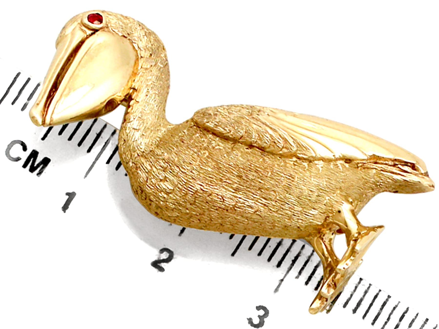 Round Cut 1980s Ruby and Yellow Gold Pelican Brooch For Sale