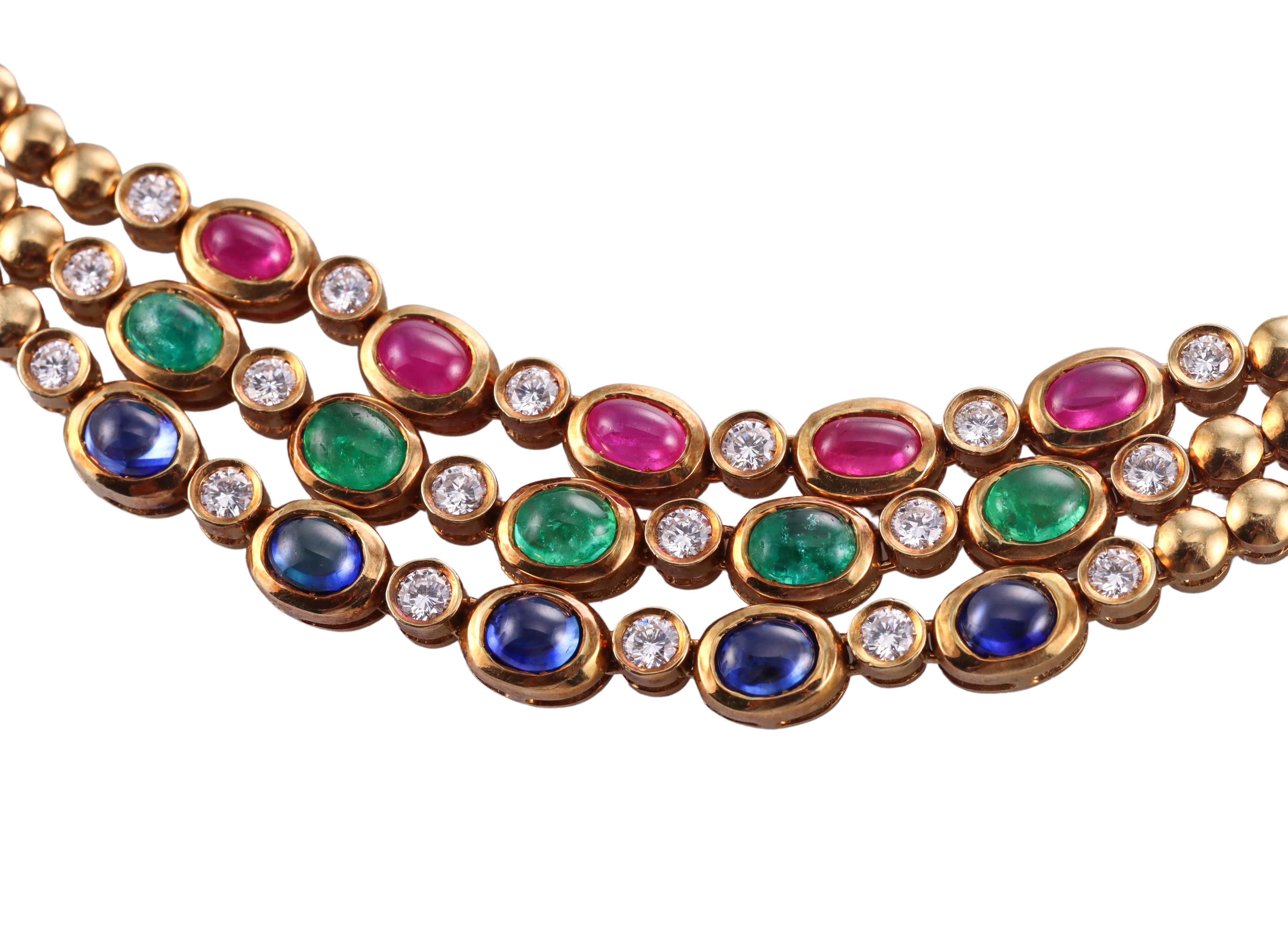 1980s vintage 18k yellow gold necklace, featuring three gold strands, set with oval emerald, ruby and sapphire cabochons, as well as a total of approximately 2.40ctw G/VS diamonds. Necklace is 15.5