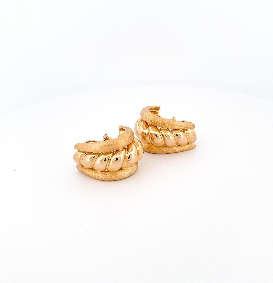 From designer Sabbadini, circa 1980’s, 18 karat yellow gold satin twisted center earrings. These earrings are crafted with twisted center designer placed in-between polished sides. These earrings feature clip back closures and a satin finish border.