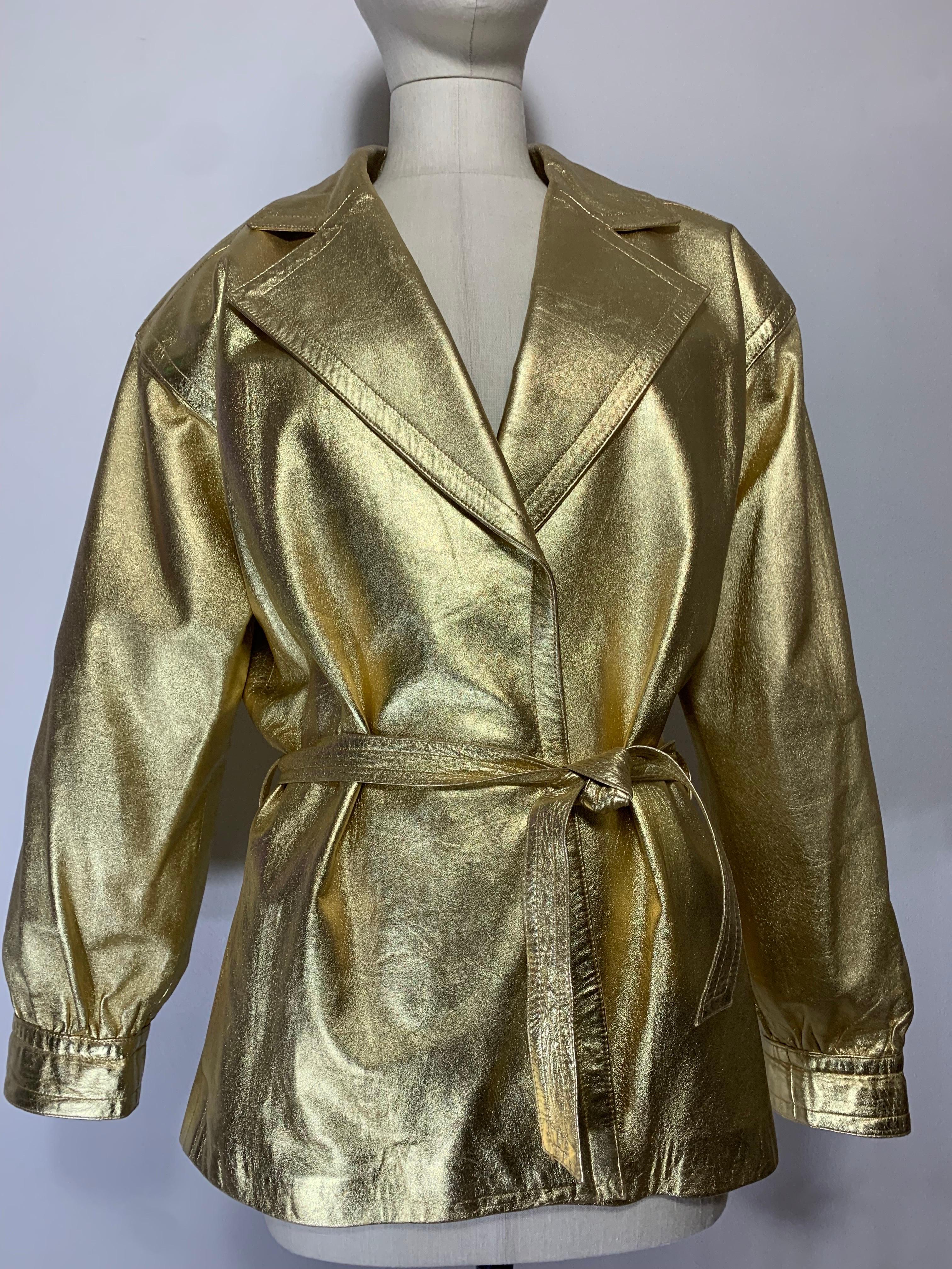 1980s Saint Laurent Gold Soft and Supple Leather Hip-Length Trench Coat In An Oversized Style w Matching Belt Tie:  Large notched collar, banded cuffs, gathered sleeves. No closures and belt tie. Gold satin lining. Size EU 40. 