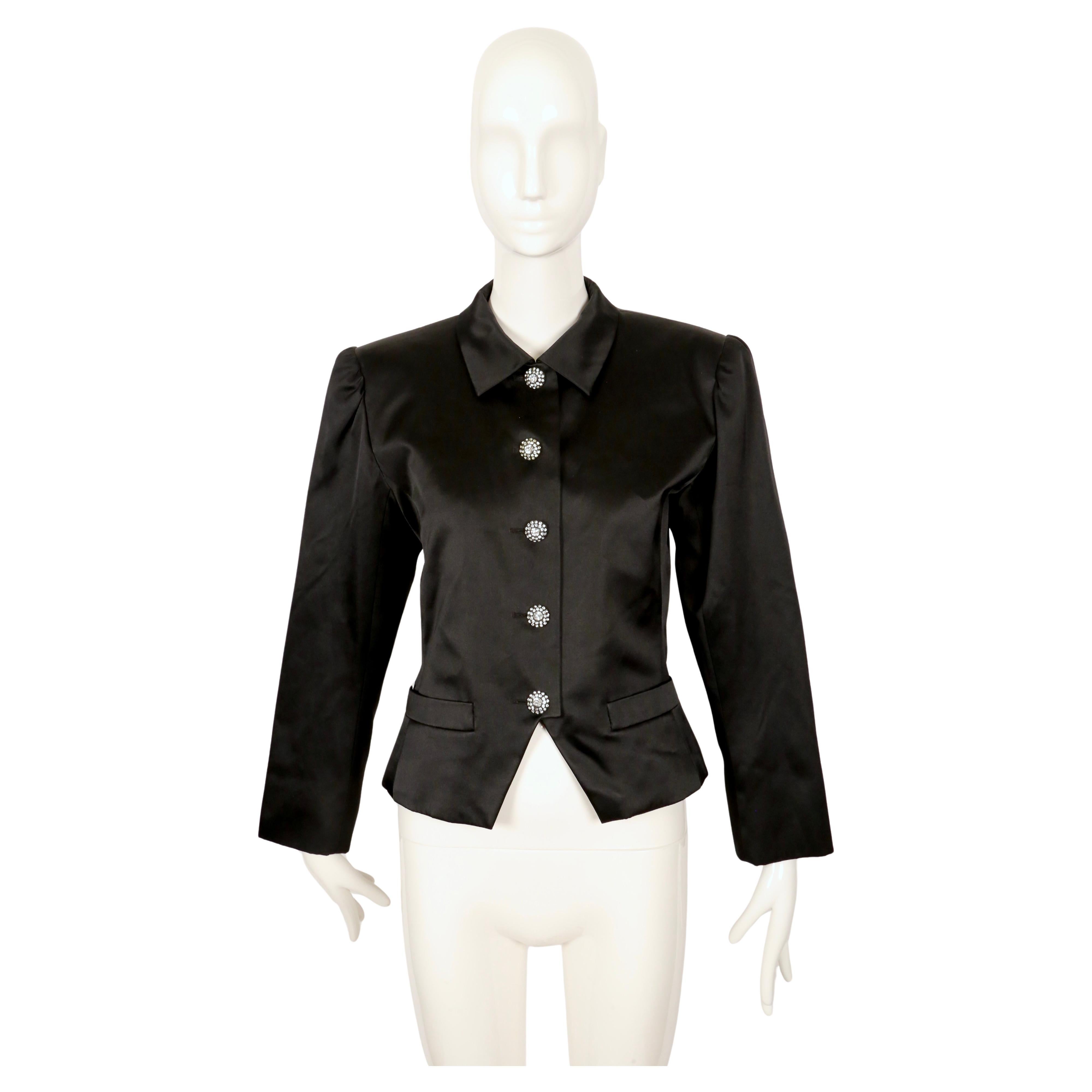 Very rare jet black satin jacket with rhinestone buttons designed by Yves Saint Laurent dating to the early 1980's. Jacket is labeled a rare French size 44. Approximate measurements: shoulders 17