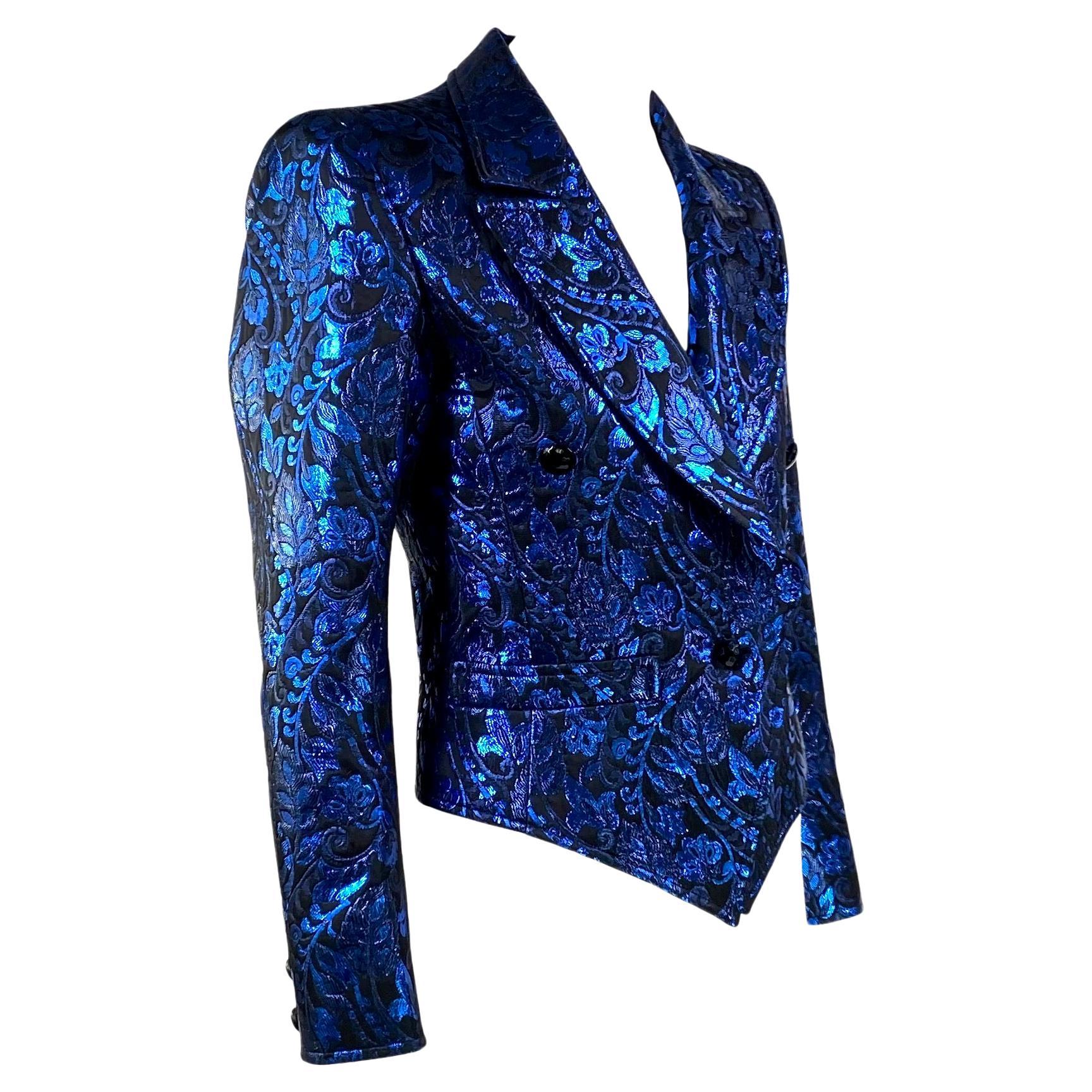 Wir präsentieren einen atemberaubenden Saint Laurent Rive Gauche Blazer aus blauem Metallic-Lamé, entworfen von Yves Saint Laurent. Diese Jacke aus den 1980er Jahren verfügt über zwei Vordertaschen, ein großes Revers und einen Pseudo-Doppelreiher.