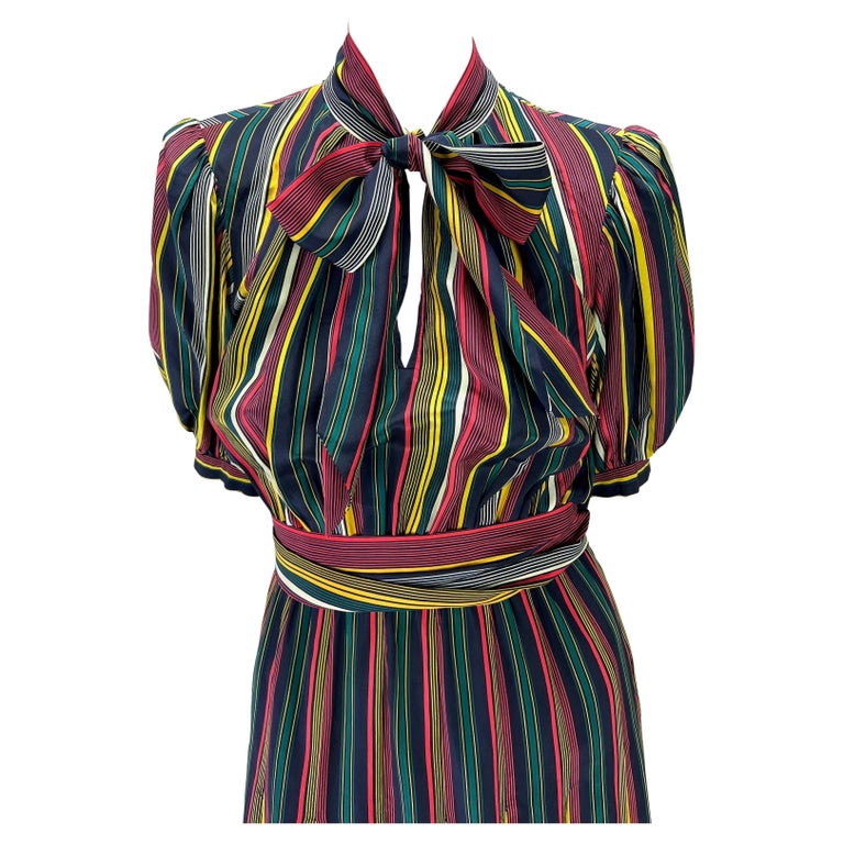 TheRealList presents: a stunning multicolor striped Saint Laurent Rive Gauche dress, designed by Yves Saint Laurent. From the 1980s, this effortlessly chic dress is the perfect vintage piece to add to any wardrobe. This dress features puffy arms,