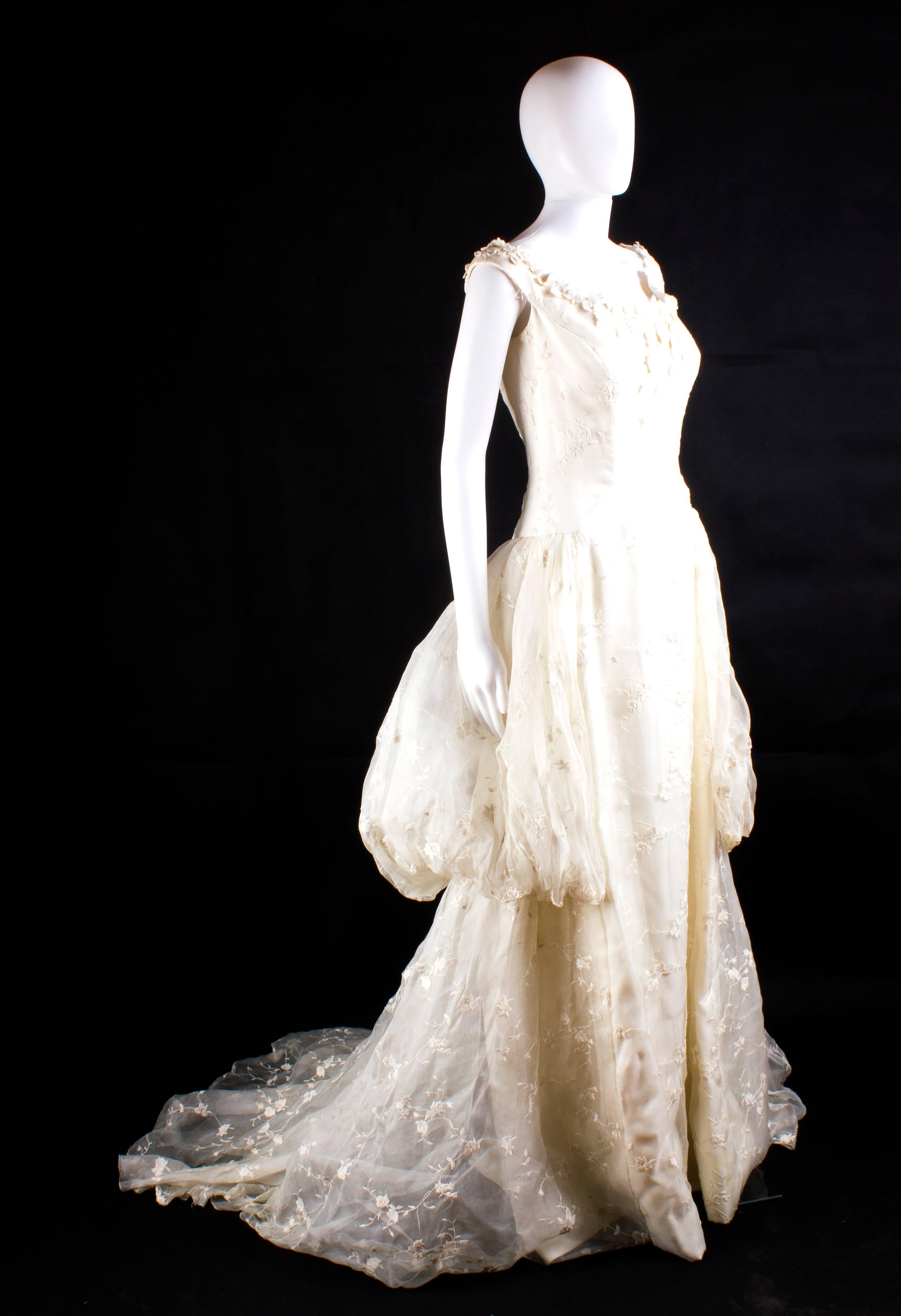 Beautiful wedding dress signed by Fausto Sarli (1927-2010) in late 80'S, one of the most creative italian haute couture designer. The gown, made in white Mikado and organza silk, is decorated with simple and elegant little flower embroidered. Size: