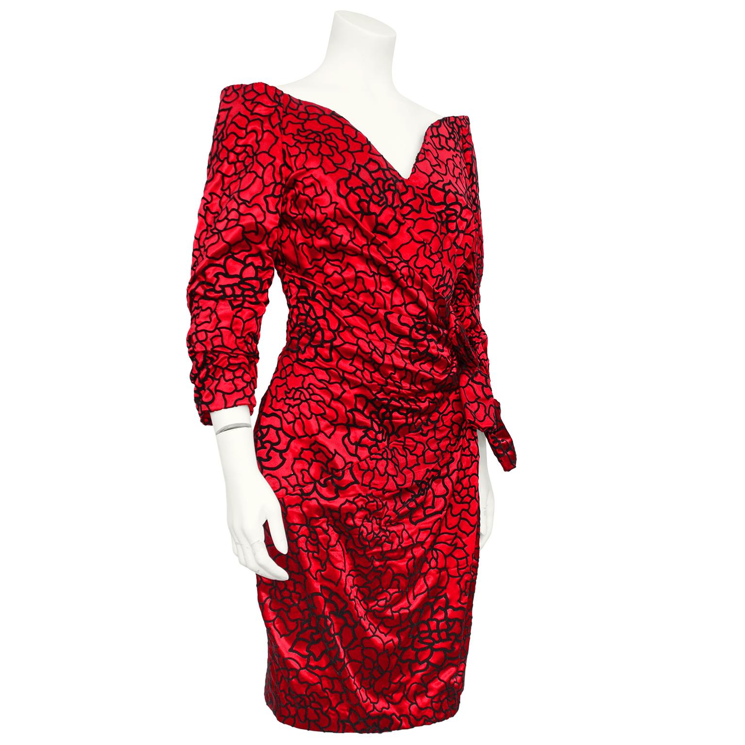 Beautiful Scaasi cocktail dress from the 1980s. Red satin with allover black velvet flocked pattern creating the outlines of flowers. Off the shoulder with a sweetheart neckline and ruched bracelet length sleeves. Diagonal ruching across the stomach