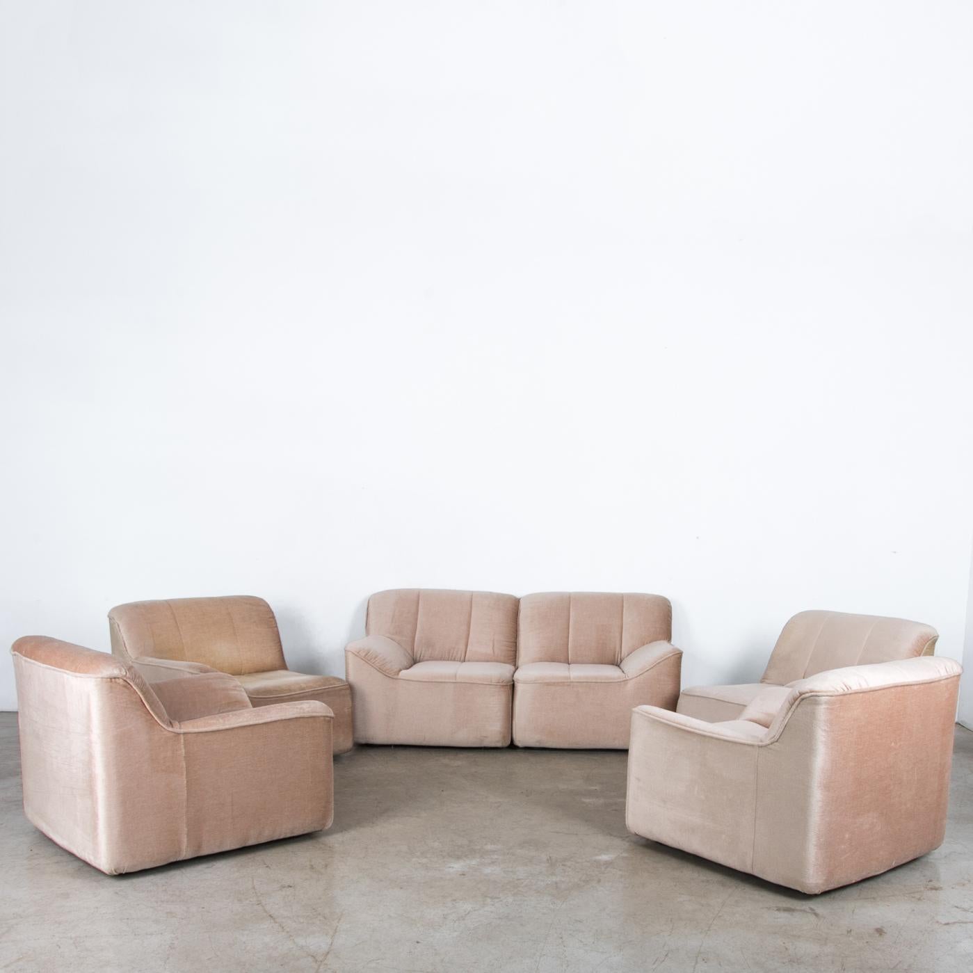 This sofa set can be configured as you please, includes two love seats and two armchairs. A Scandinavian piece from circa 1980 with a typical period design, streamlined and pastelized in original fabric, a vivid salmon. One unit shows slight wear