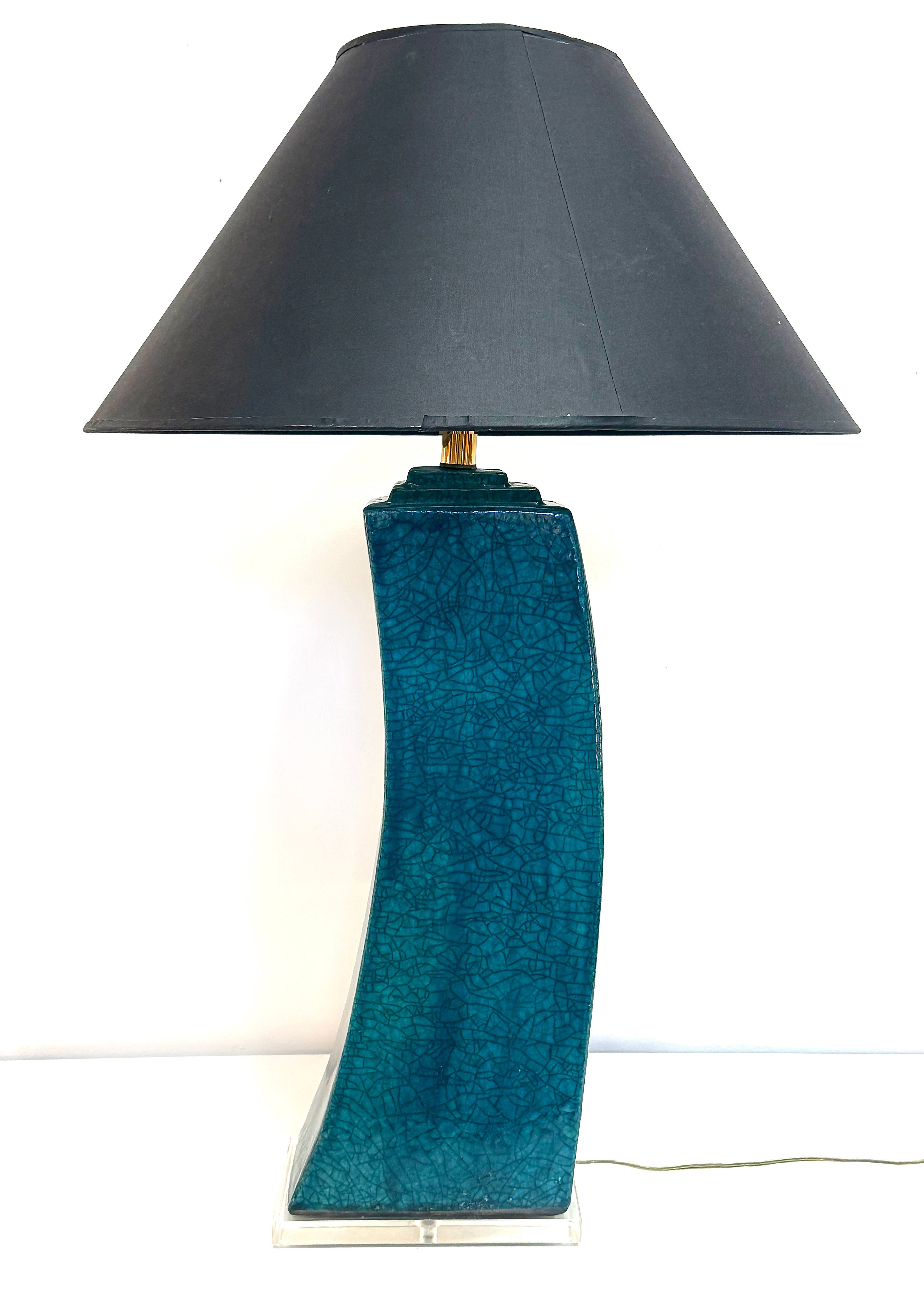 1980s Sculptural Ceramic Glazed Table Lamp on Lucite Base, Signed and Numbered

Offered for sale is a 1980s signed and numbered ceramic table lamp mounted on a Lucite base. The curved sculptural lamp retains the original shade. The lamp has a  great