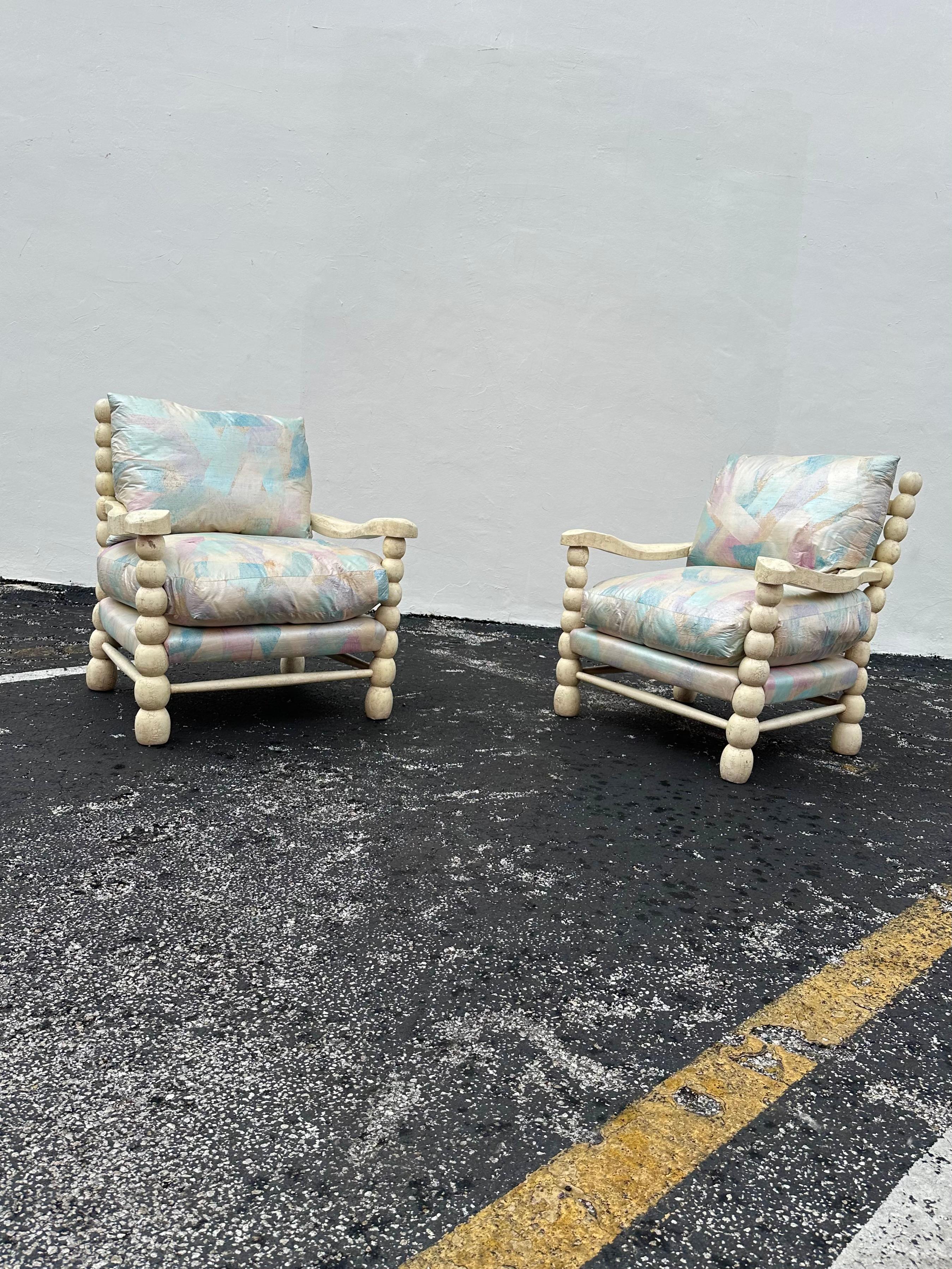 Transport yourself back to the sleek and sophisticated 1980s with this exquisite rustic large bobbin style chairs. Original pastels shimmery upholstery. The ultra rare chairs exudes an air of luxury and refinement. Outstanding design is exhibited
