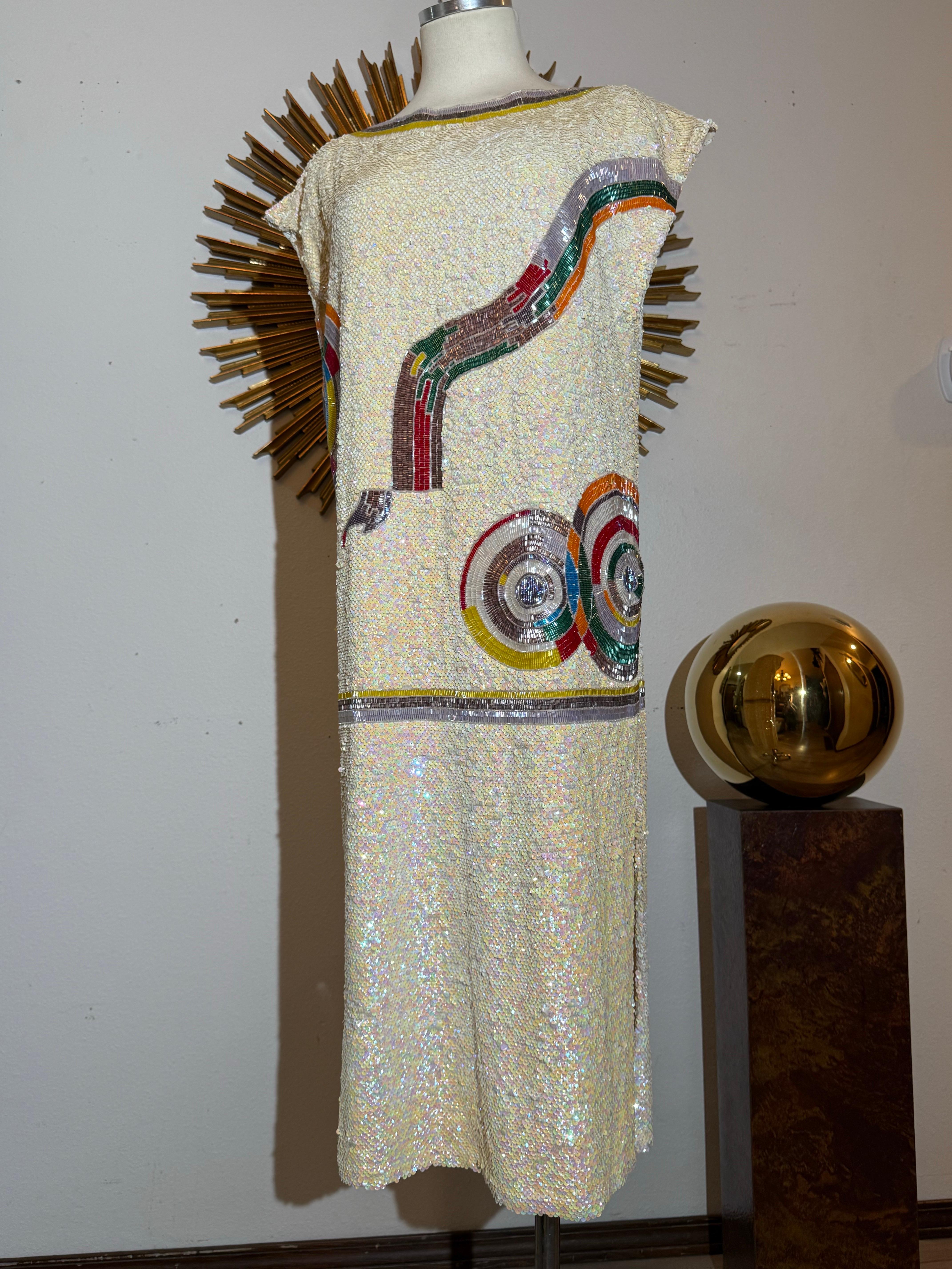 1980s Sequin Drop-Waisted Shift Dress w Deco-Style Graphic Motif on Silk Crepe: Simple, drop-shoulder, straight silhouetee with deep side slit on left side. Micro sequins hand applied in a pinwheel pattern and kaleidoscope colors on a