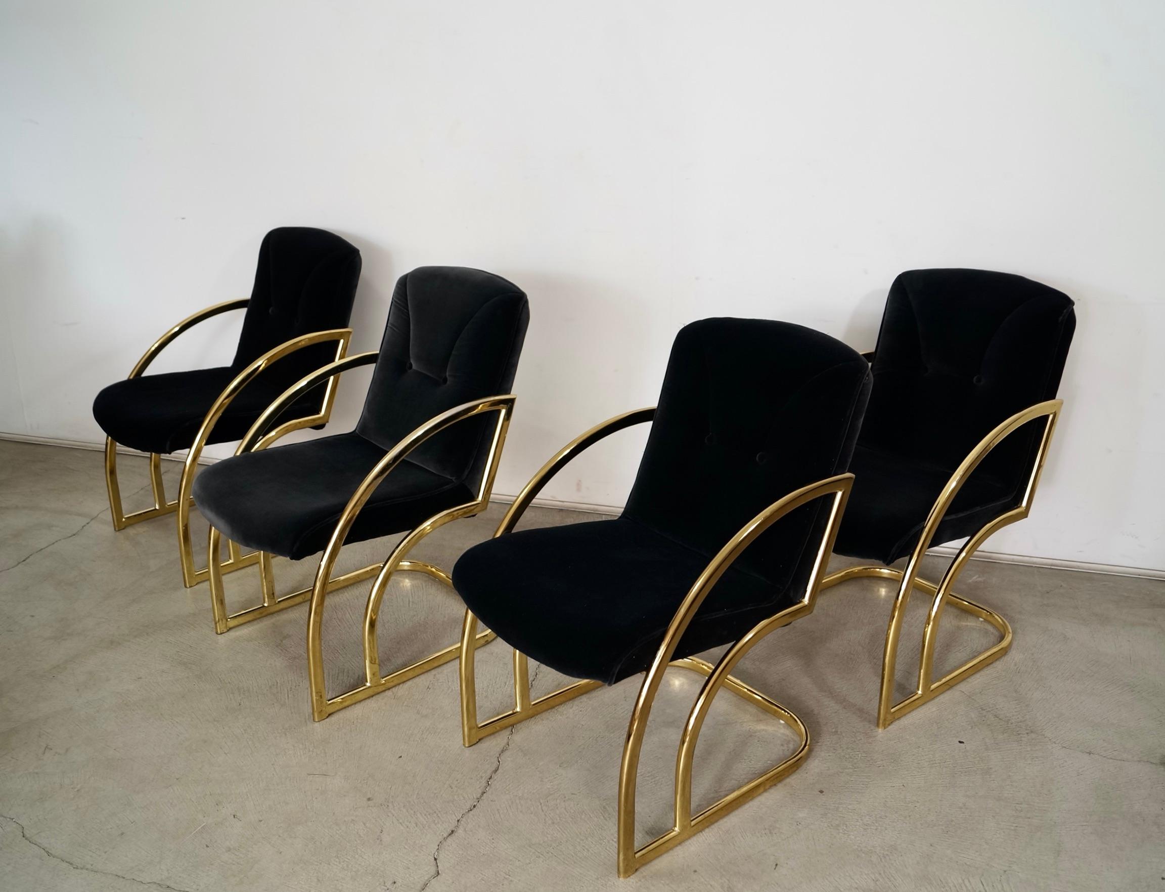 Set of 4 vintage Art Deco dining chairs for sale. They are from the late 1970's / early 1980's, and were manufactured by Bassett Furniture here in the US. They are very high-quality brass armchairs, and very solid. They have a brass cantilever Art