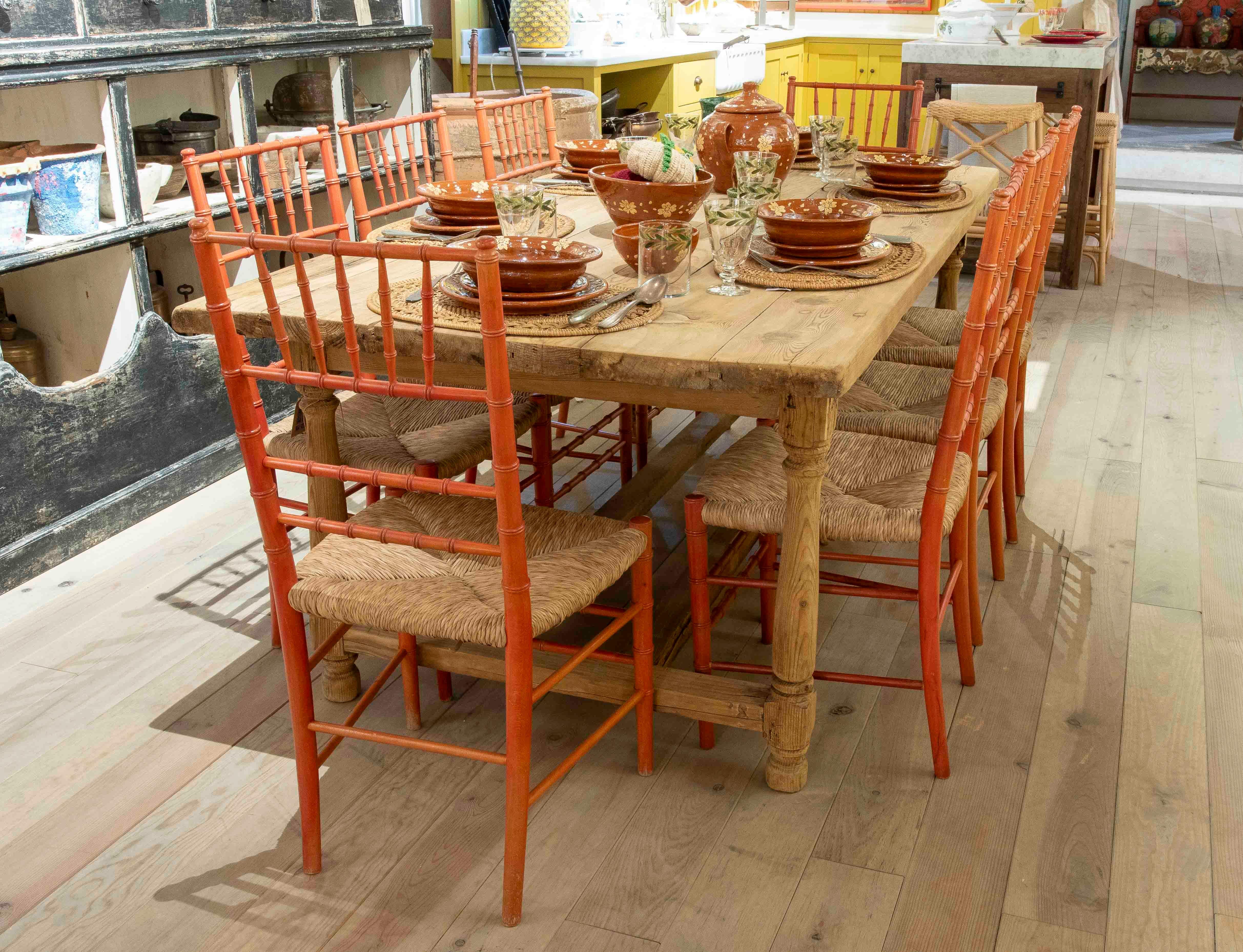 Charmant ensemble de huit chaises provençales ou paysannes de style français, fabriquées en bois peint dans une teinte rouge corail avec une jolie finition vieillie. Chaque pièce présente un dossier en tiges tournées et une assise en paille tressée